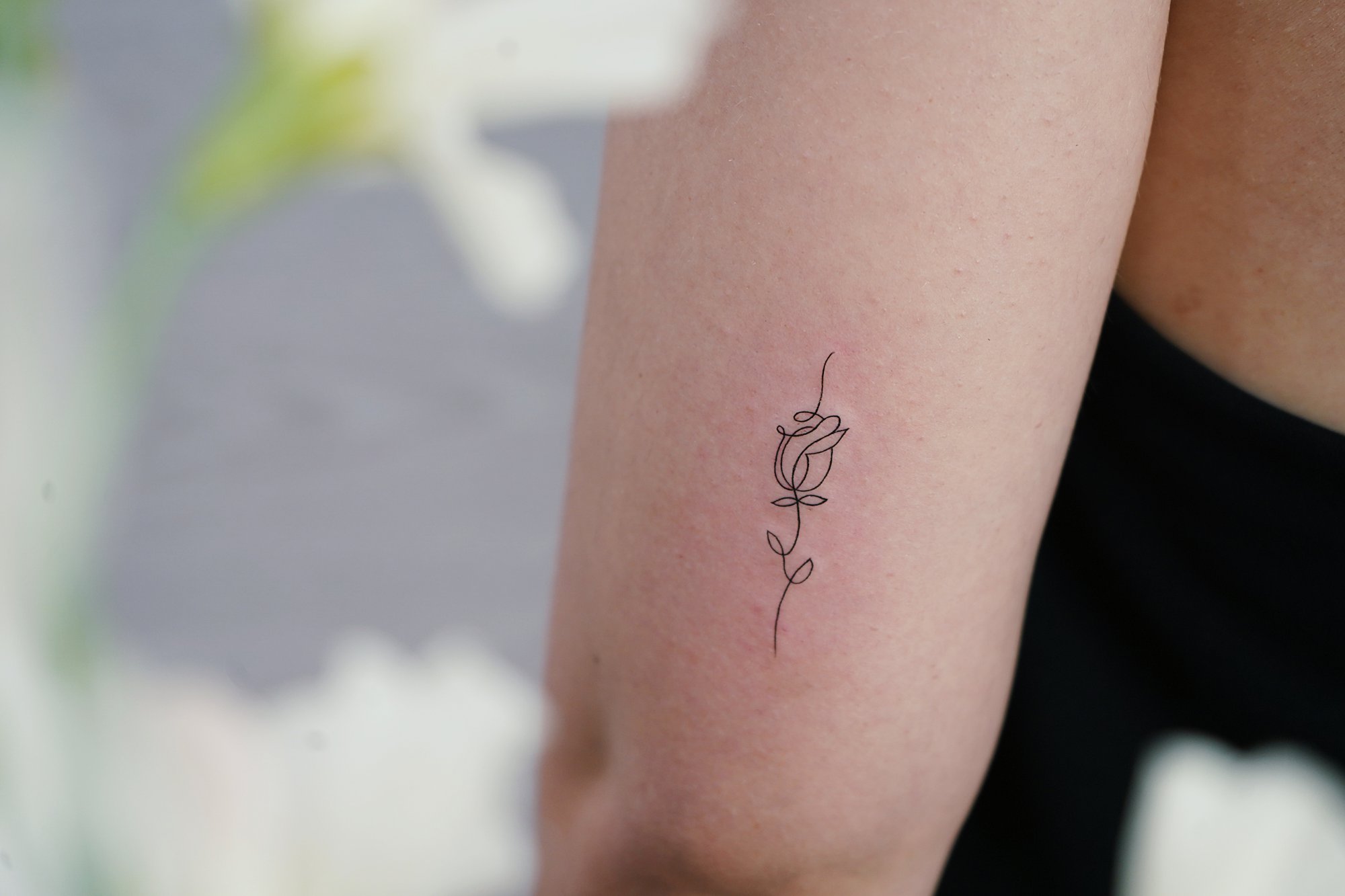 Tatuaje de flor en brazo, línea fina