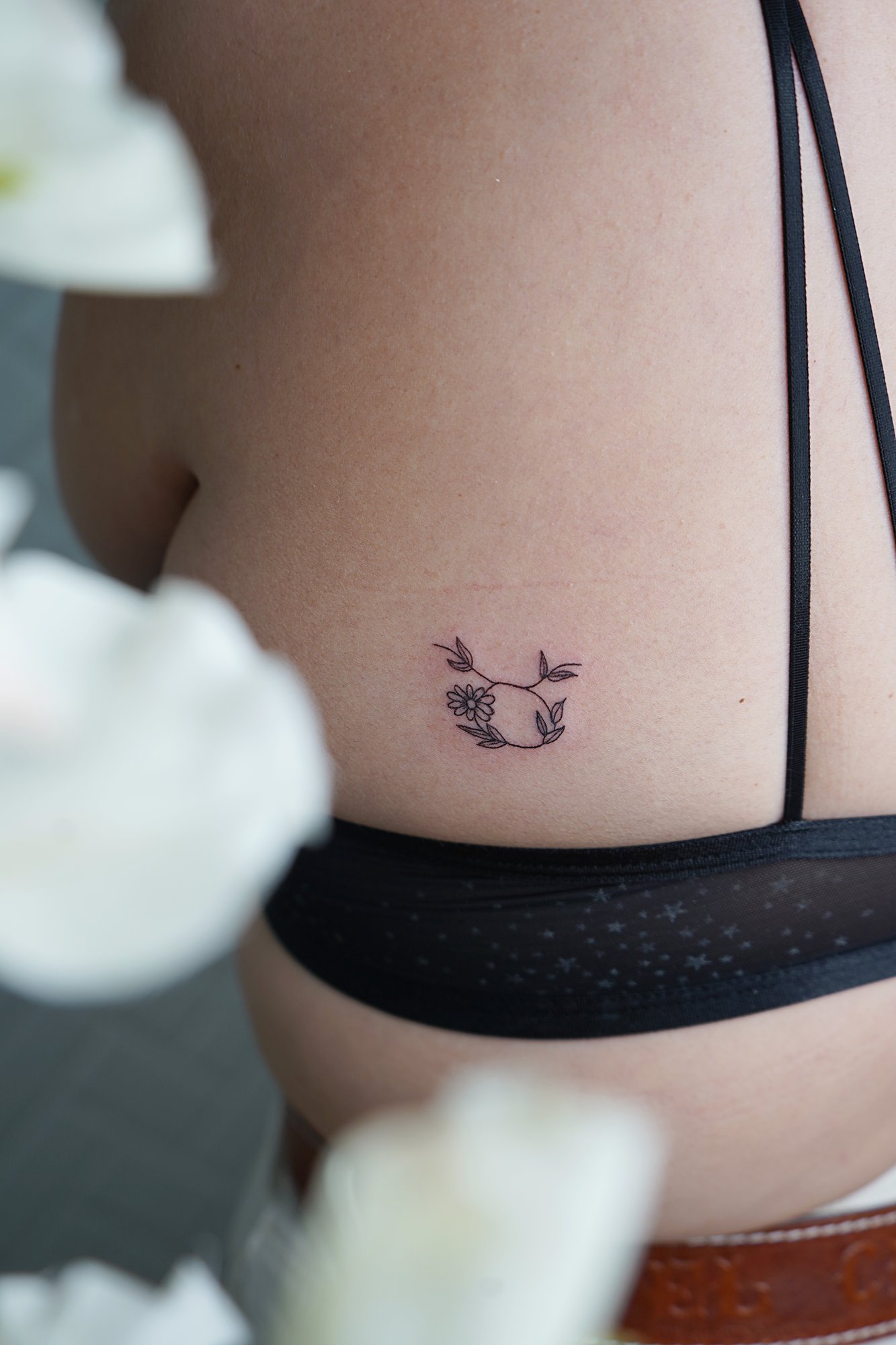 Tatuaje de flor en costilla, línea fina
