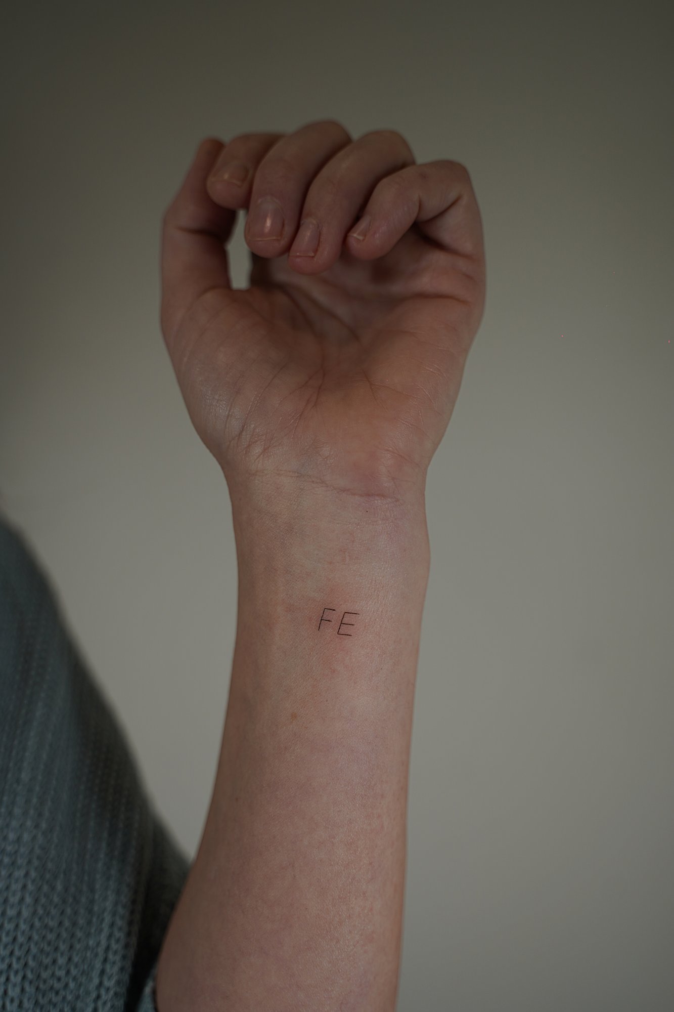 Tatuaje de flor en muneca, línea fina