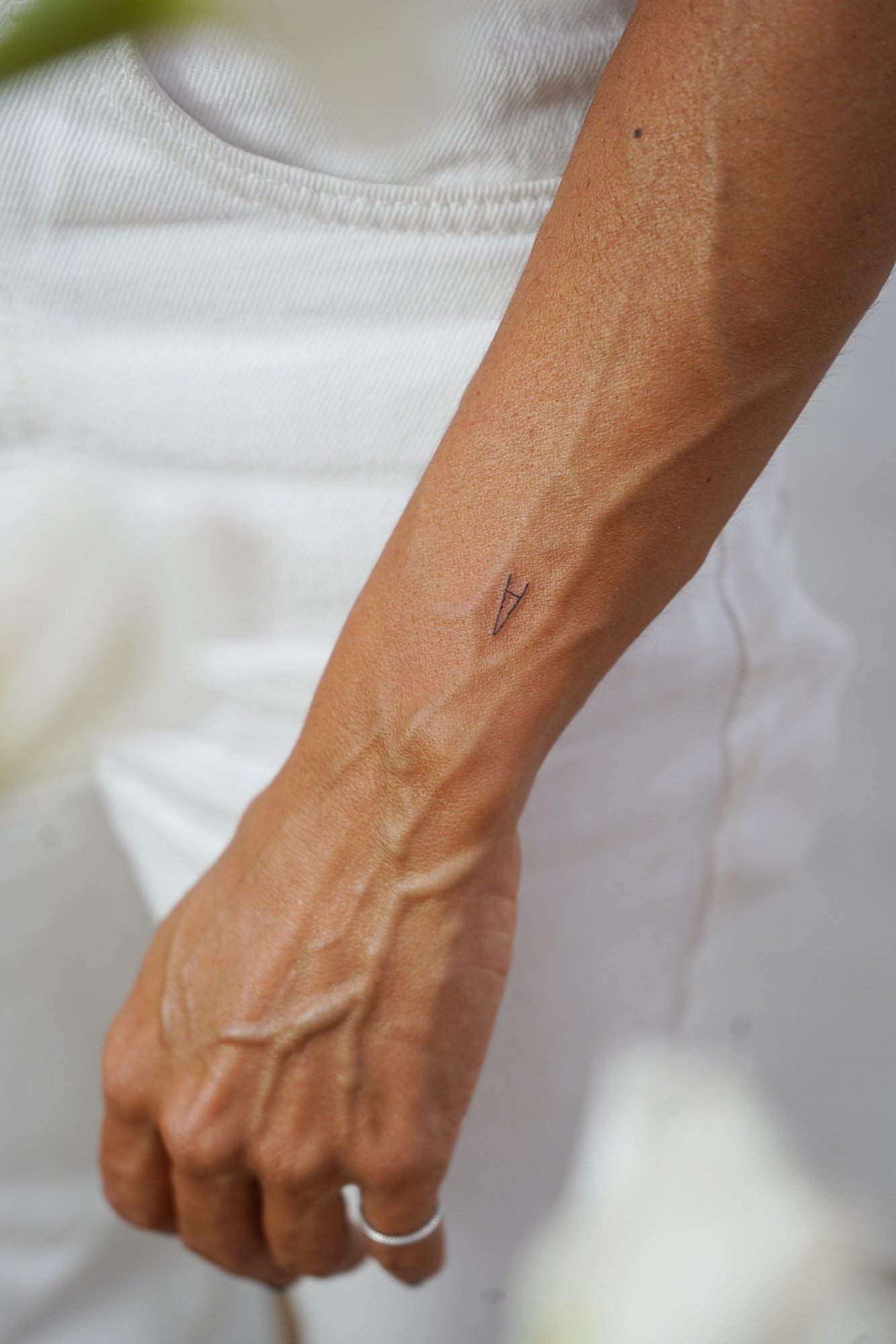 Tatuaje de flor en nuca, línea fina
