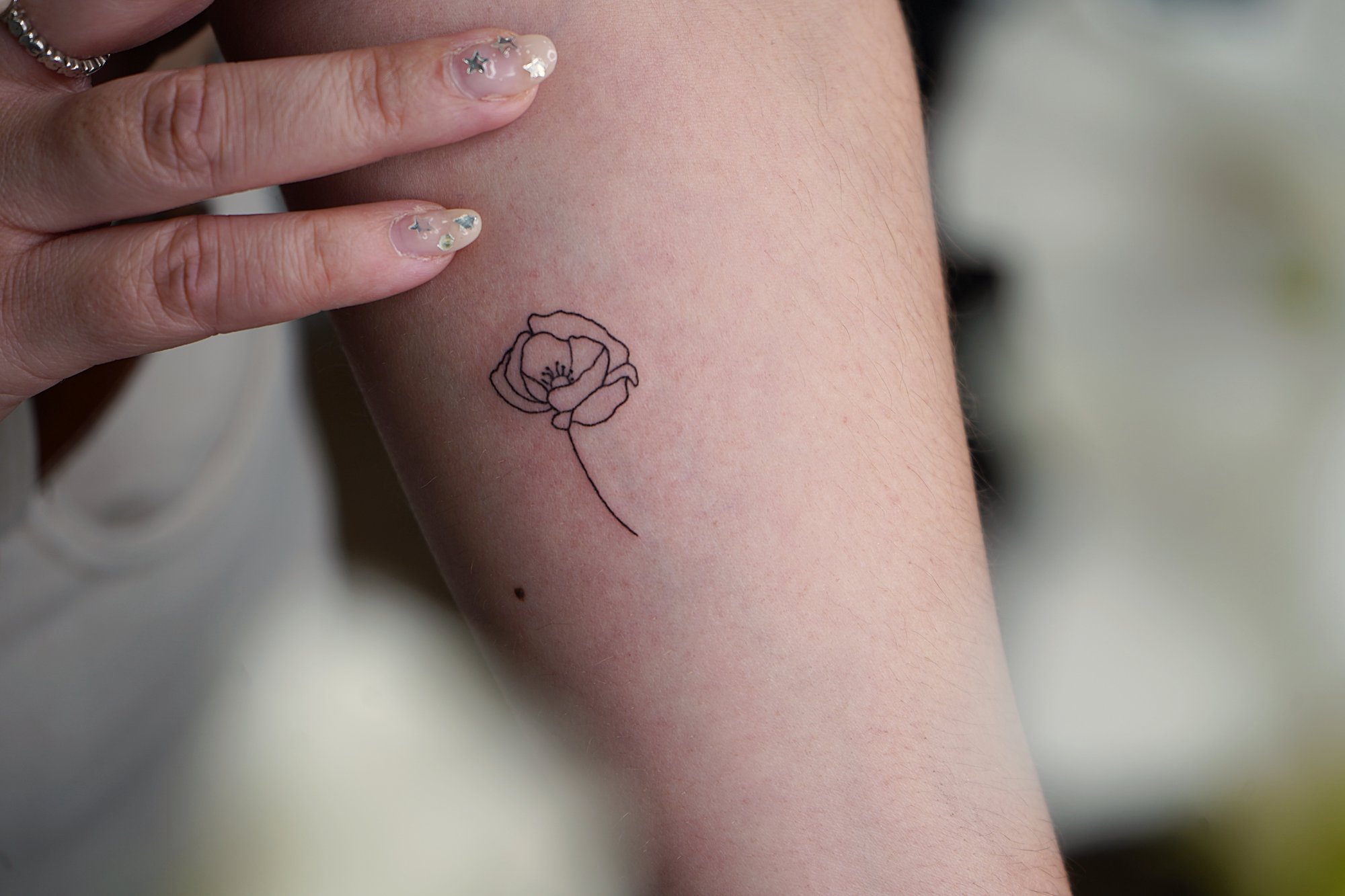 Tatuaje de flores en antebrazo, línea fina