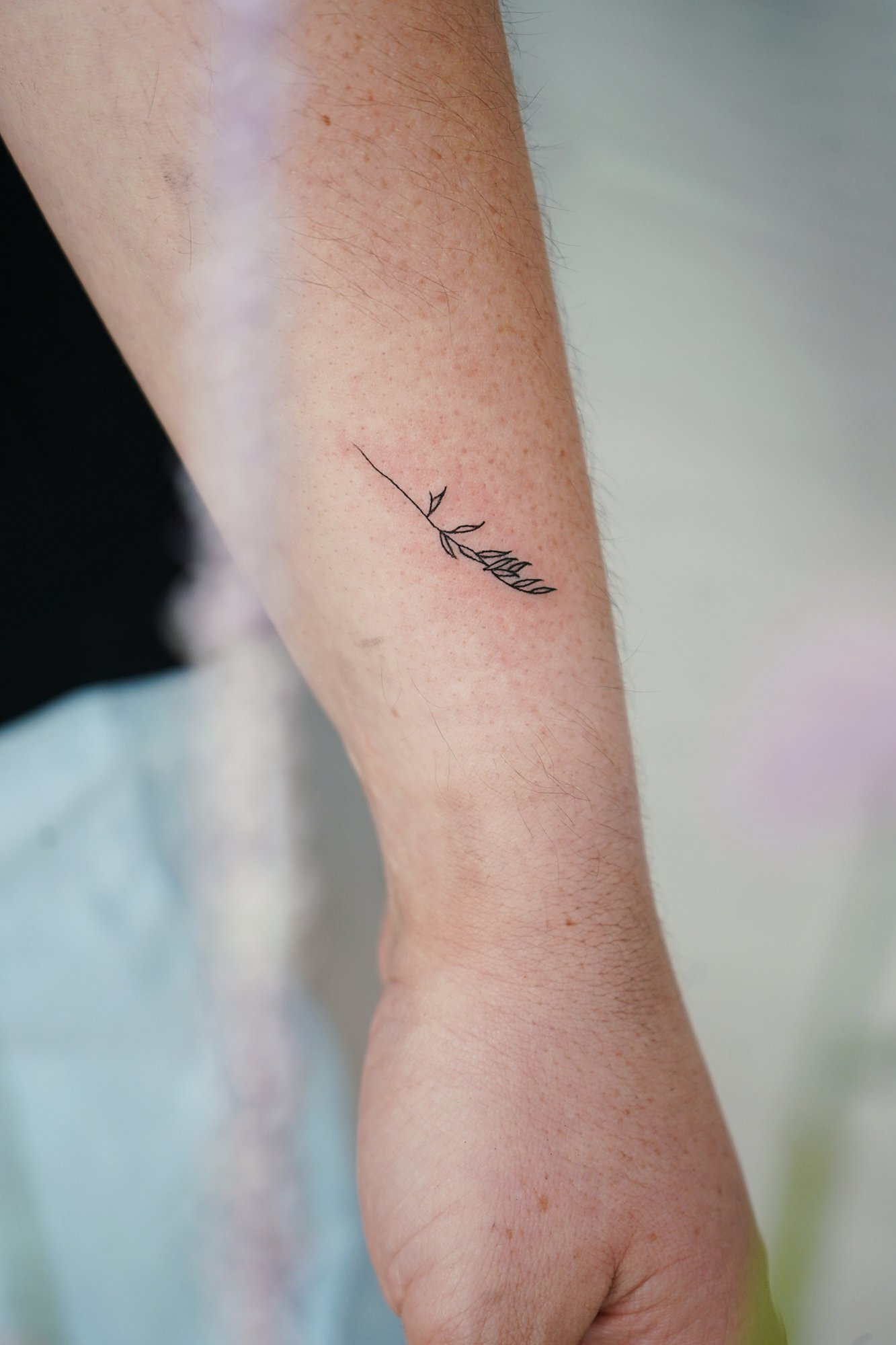 Tatuaje de rama en muneca, línea fina