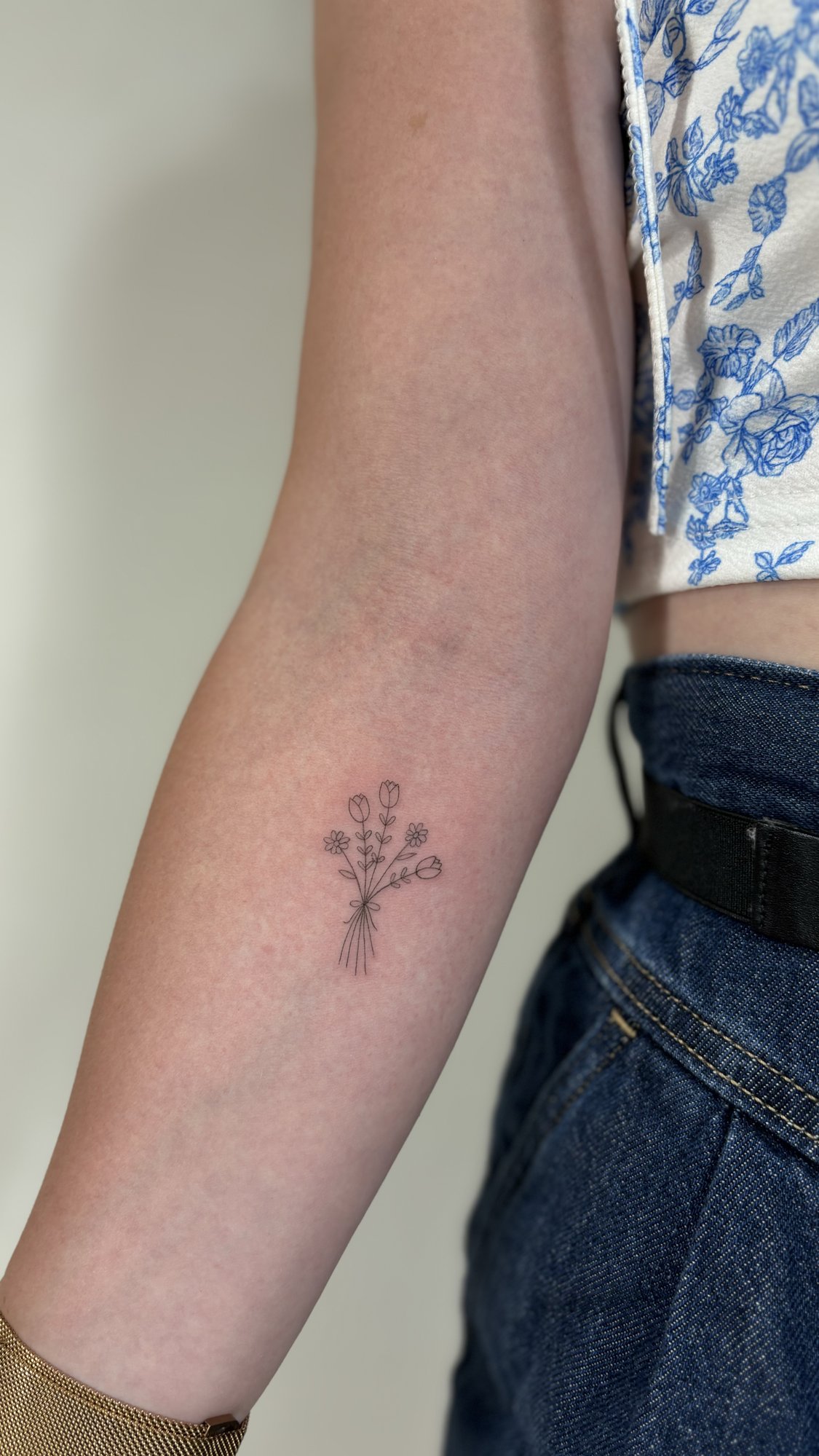 Tatuaje de ramillete flores silvestres mi en antebrazo, línea fina
