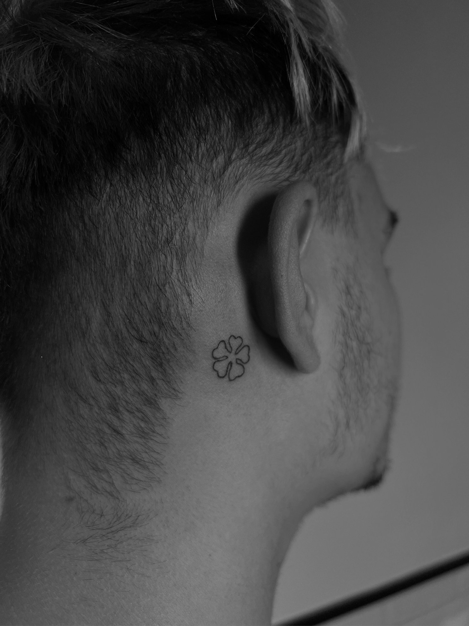 Tatuaje de trebol cuatro hojas minimalist en detras oreja, línea fina