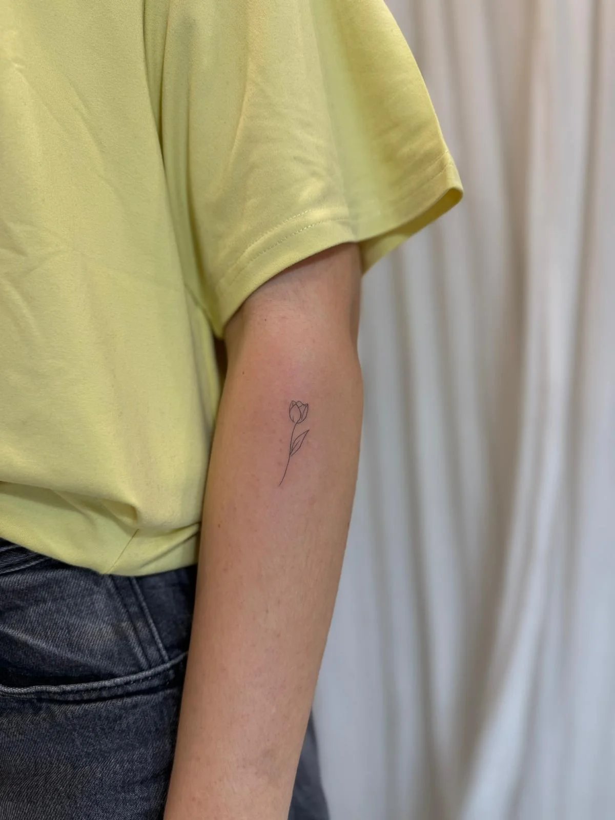 Tatuaje floral tulipan minimalista tallo antebrazo