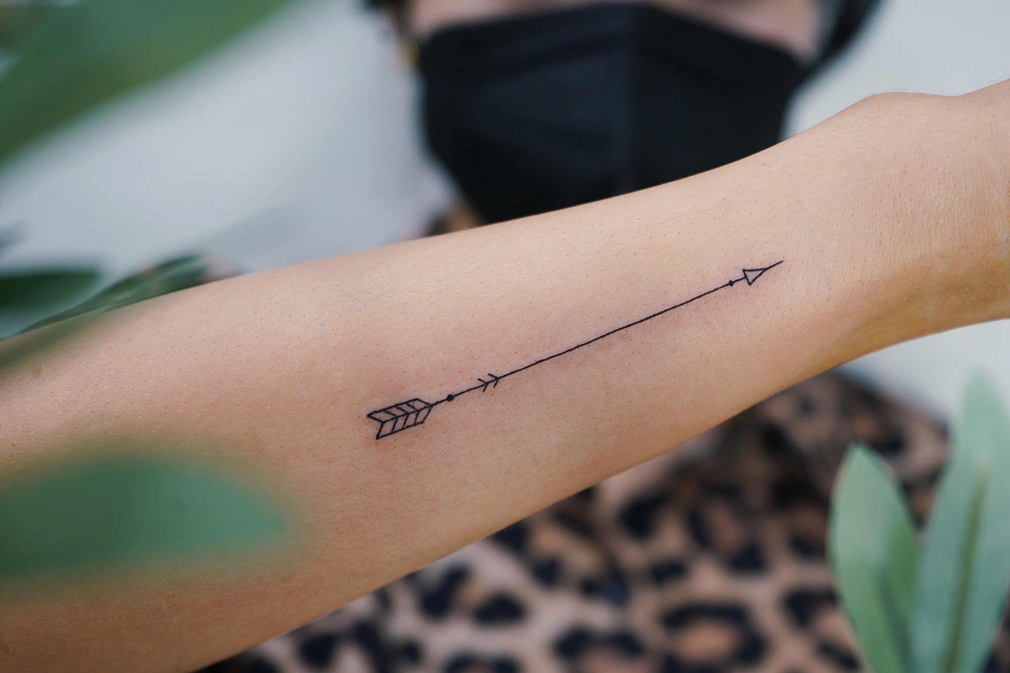 Tatuaje de flecha en muneca, línea fina