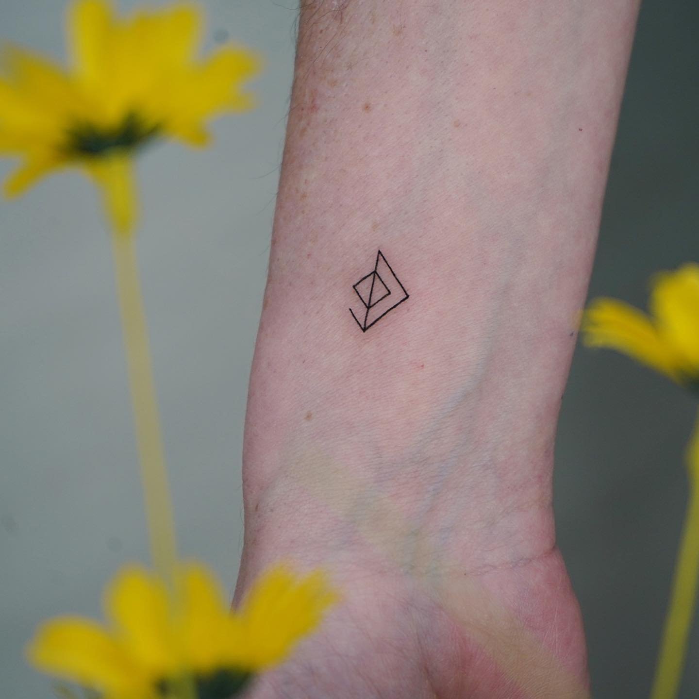 Tatuaje de geometrico en antebrazo, línea fina Sinkply Madrid