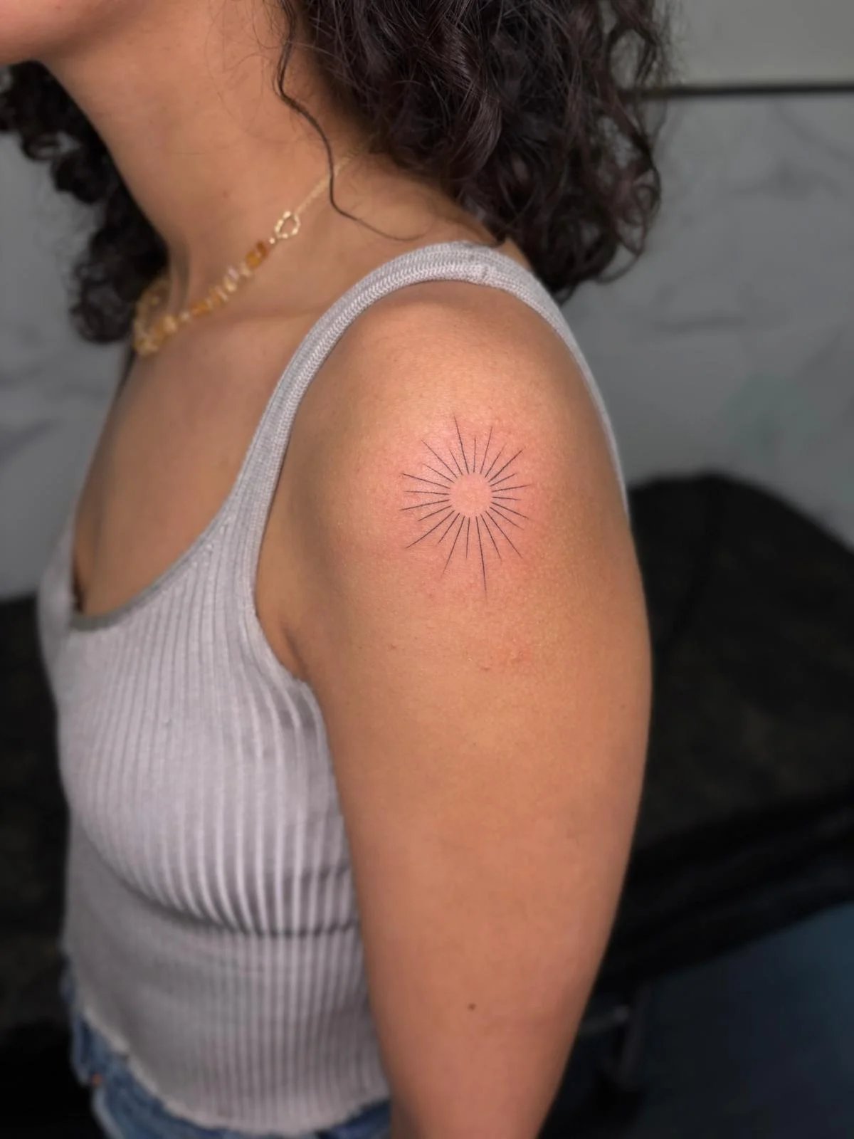 Tatuaje geometrico sol con rayos hombro