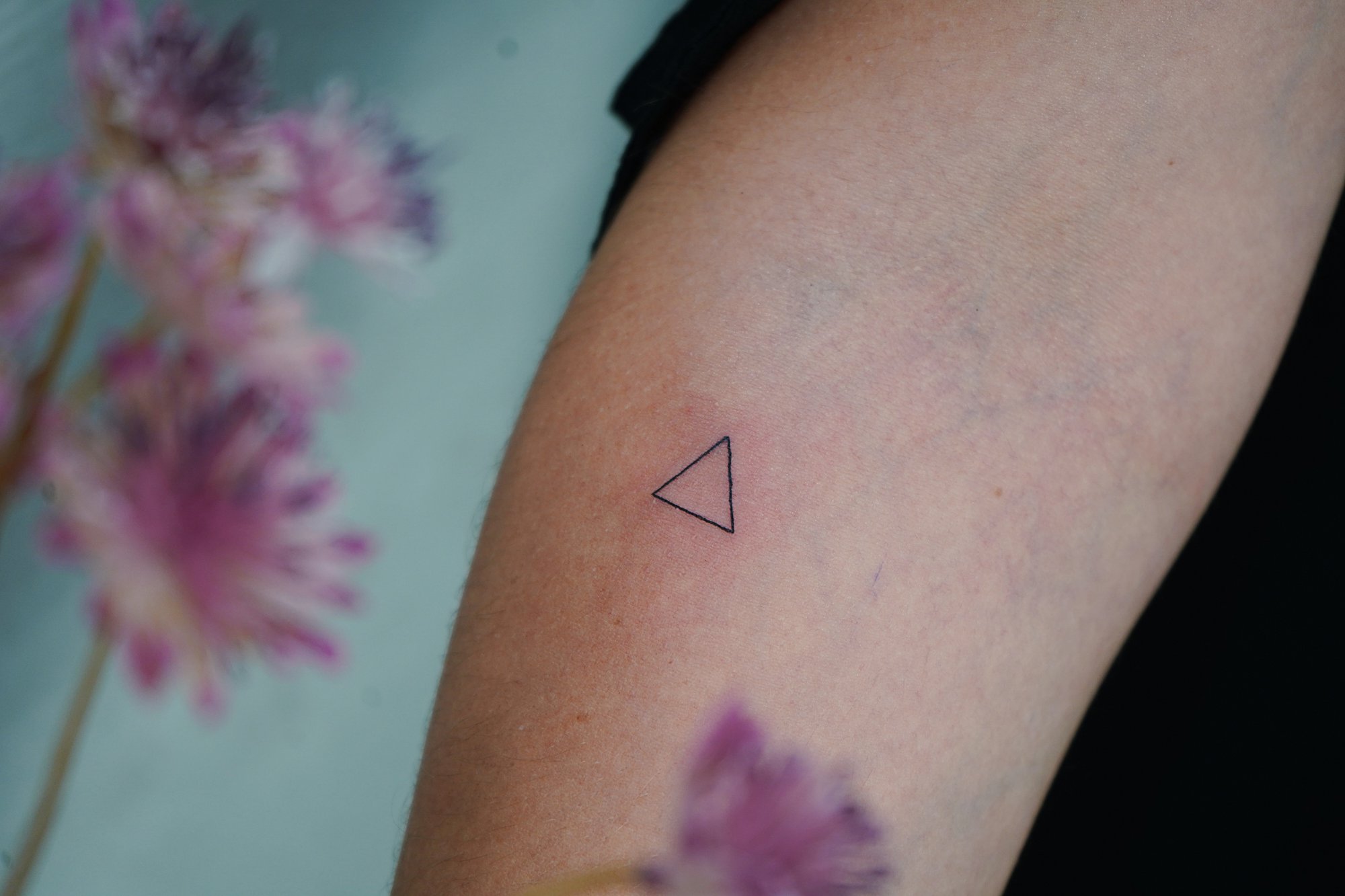 Tatuaje de triangulo en antebrazo, línea fina