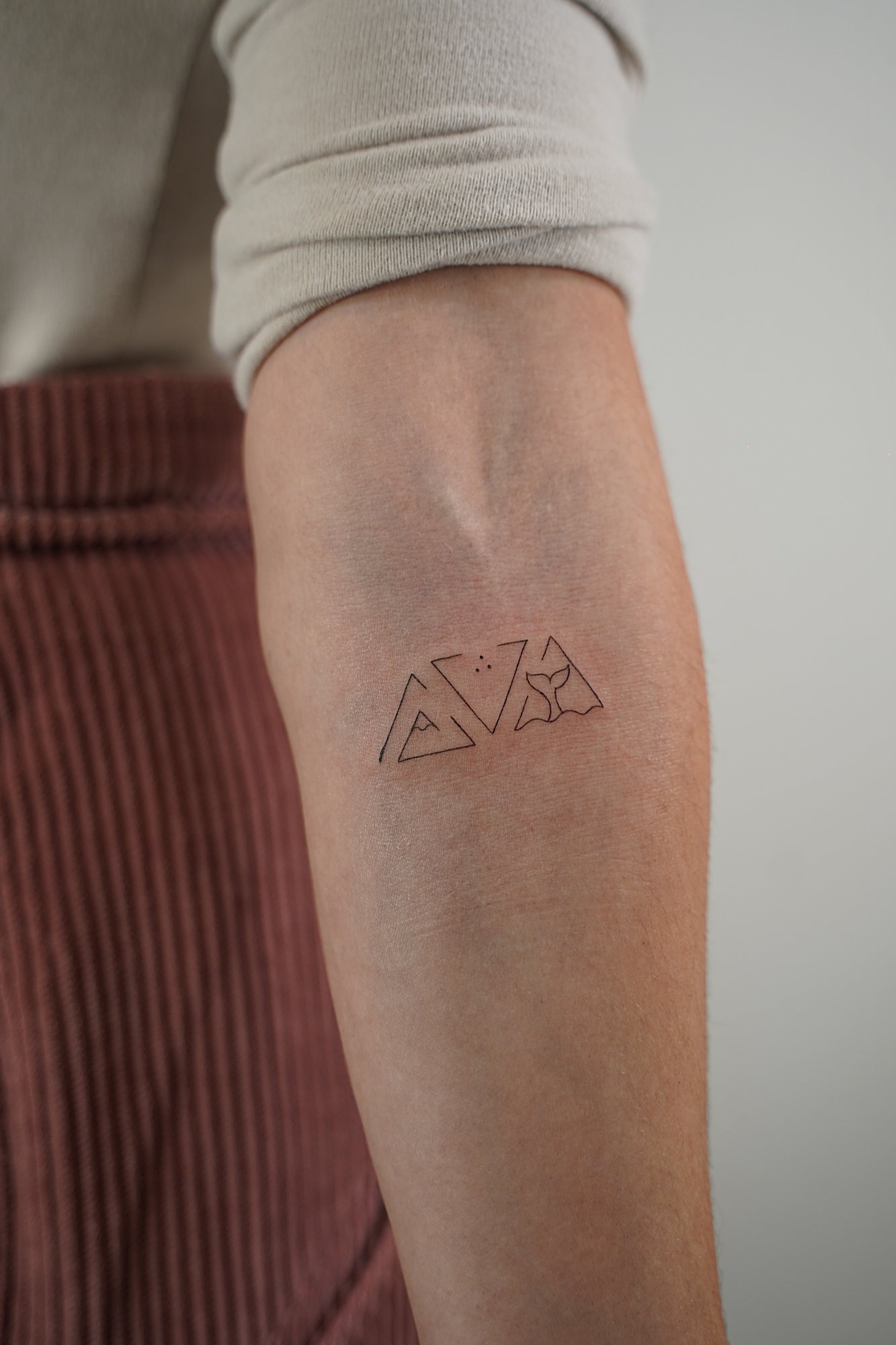 Tatuaje de triangulos en zona desconocida, línea fina