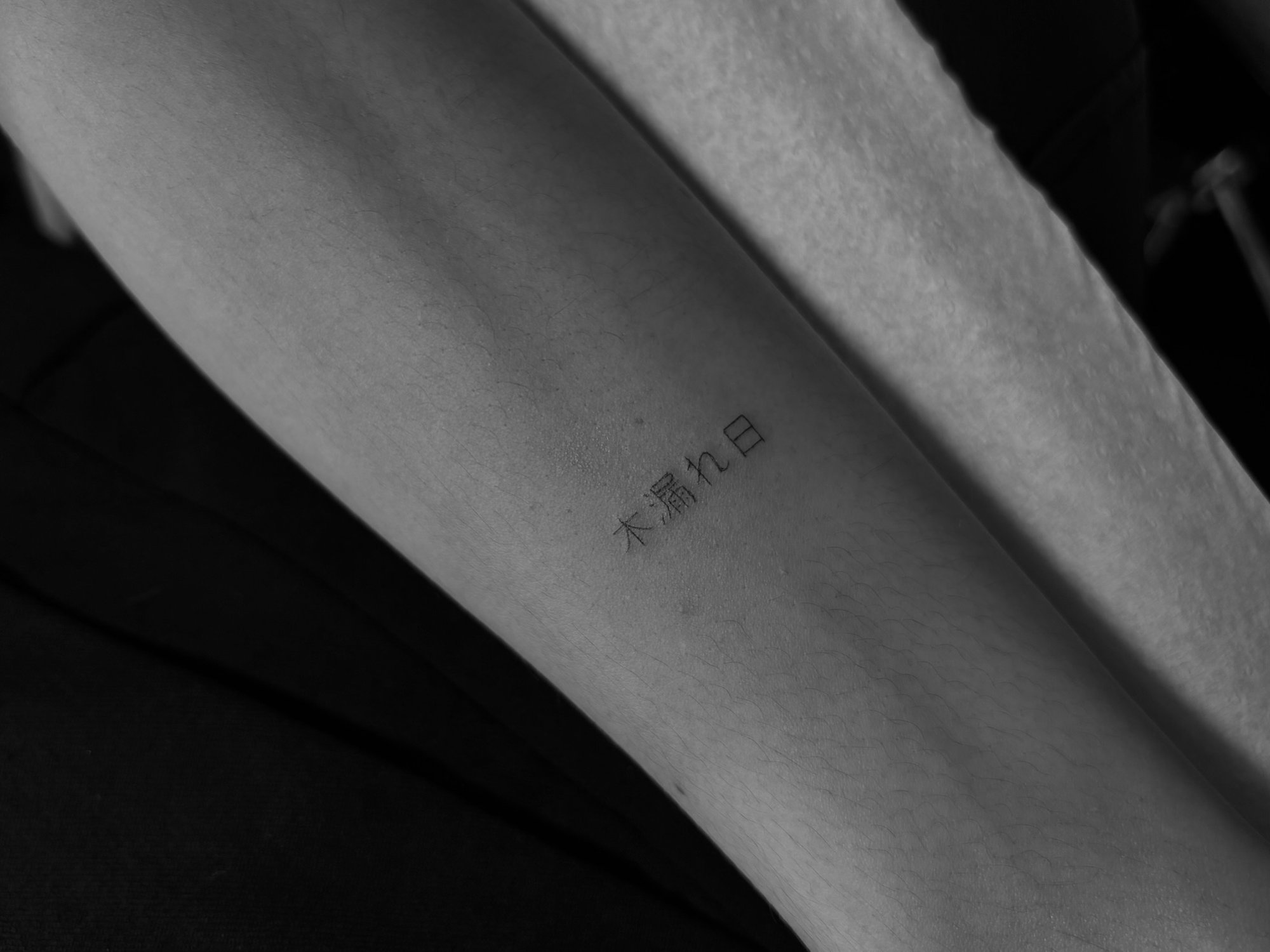 Tatuaje de caracteres japoneses komorebi en antebrazo, línea fina