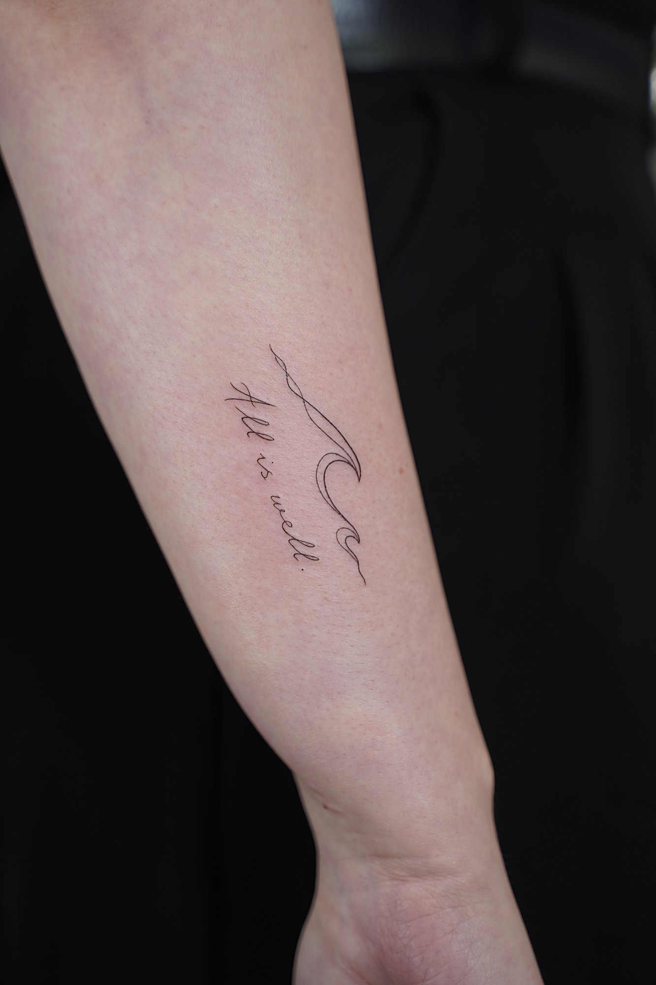 Tatuaje de frase all is well en costilla, línea fina