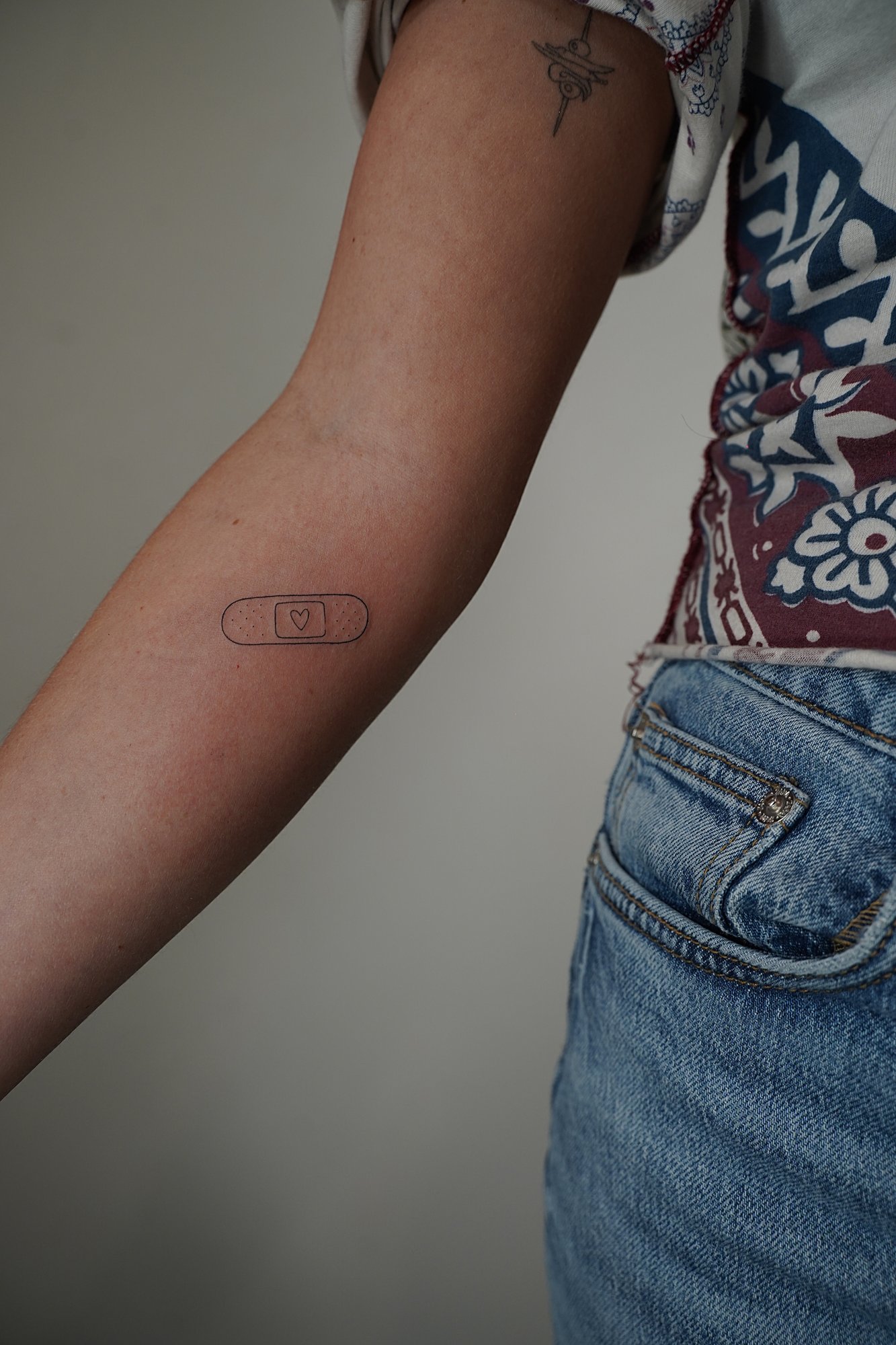 Tatuaje de frase aqui ahora en espalda, línea fina
