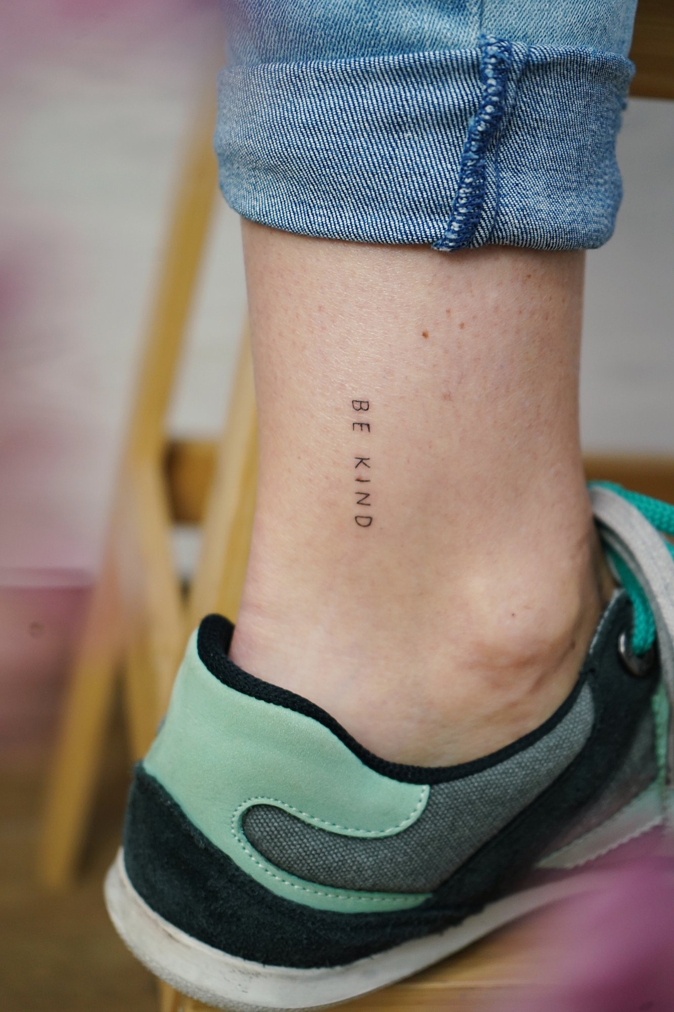 Tatuaje de frase be kind en tobillo, línea fina