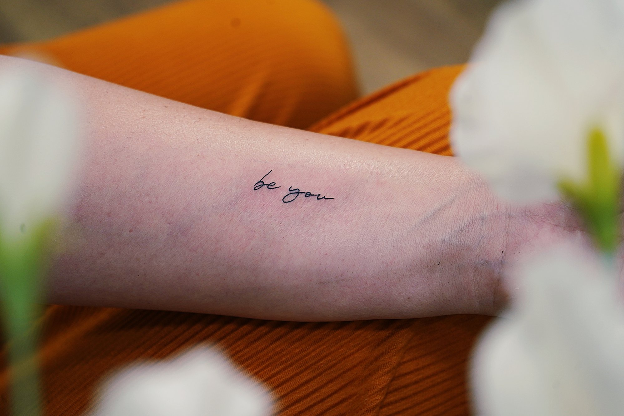 Tatuaje de frase be you en zona desconocida, línea fina
