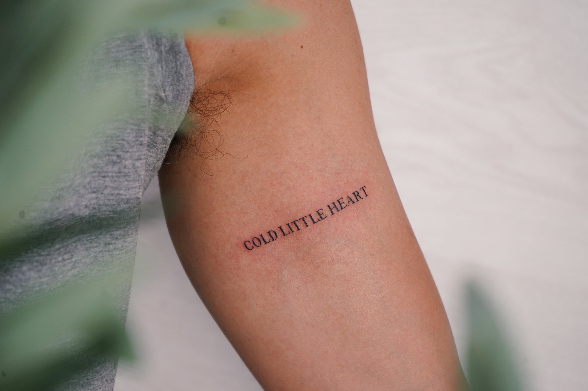 Tatuaje de frase cold little hard en brazo, línea fina