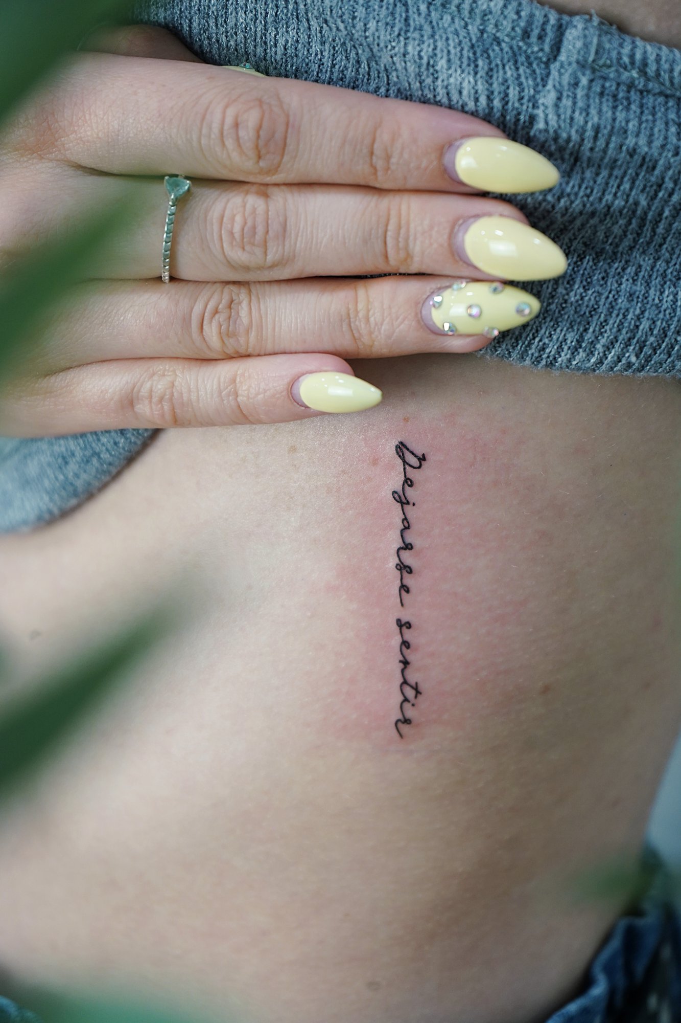 Tatuaje de frase dejarse sentir en costilla, línea fina