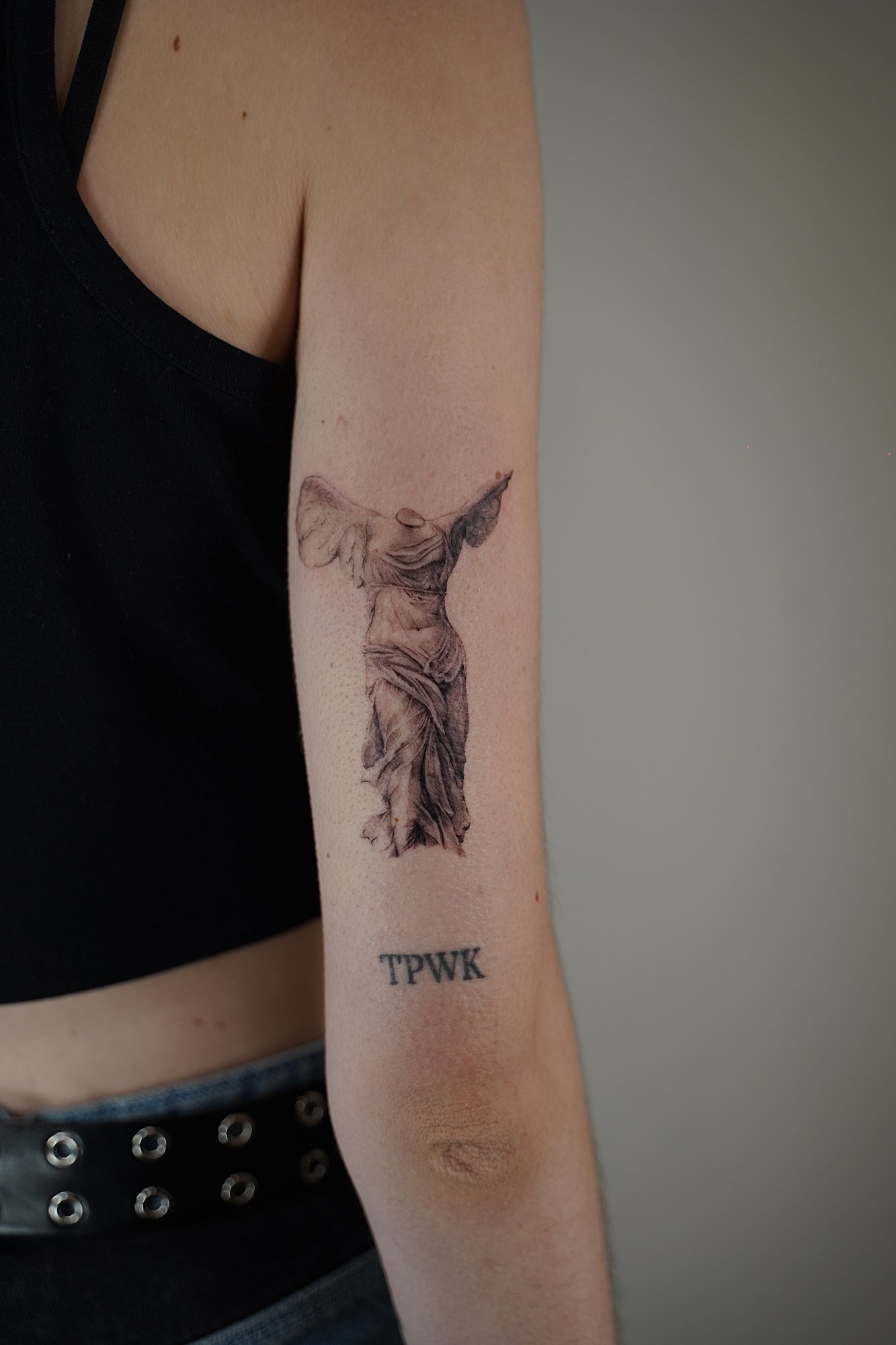 Tatuaje de frase esto tambien en codo, línea fina