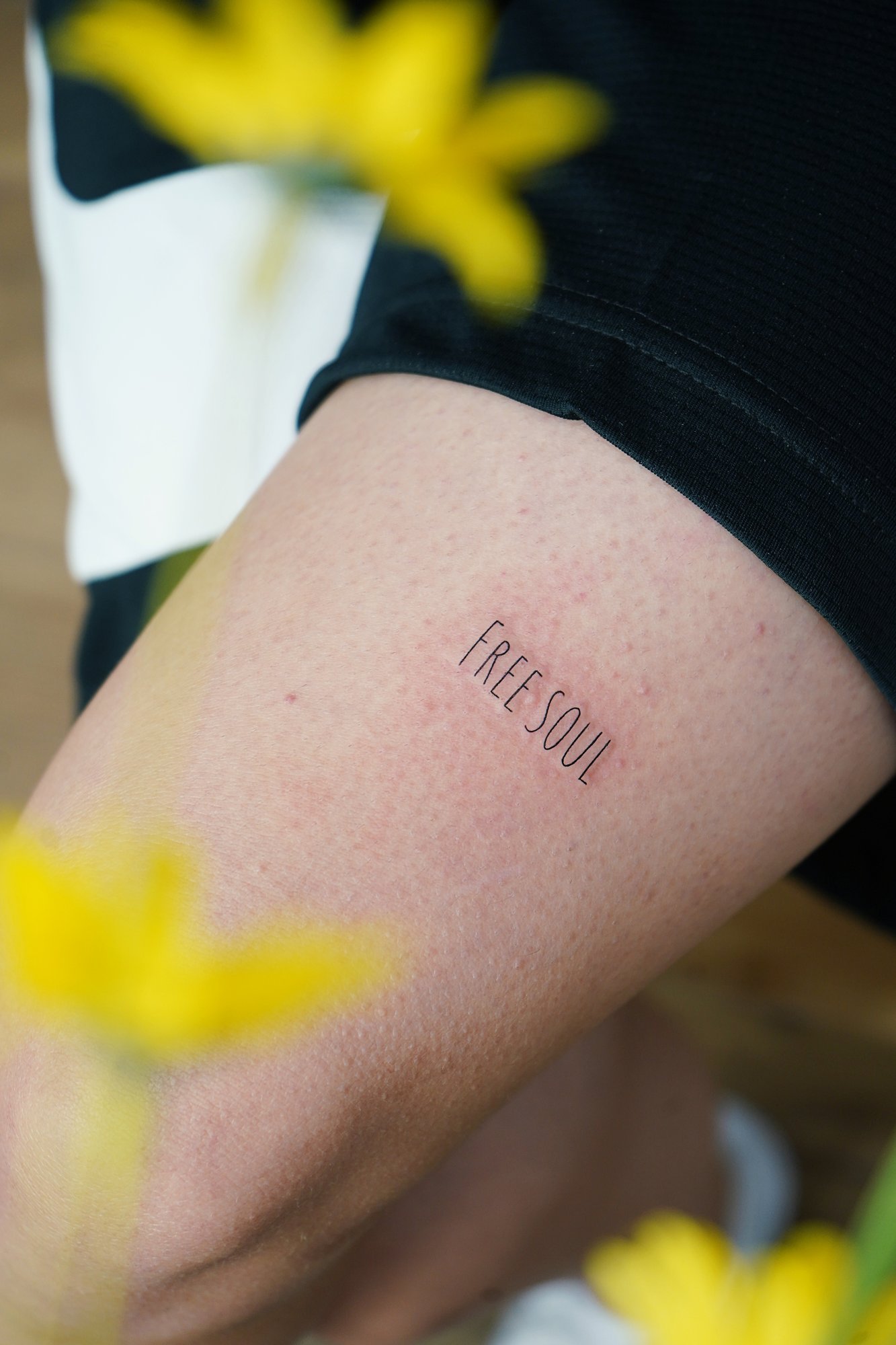 Tatuaje de frase free soul en codo, línea fina