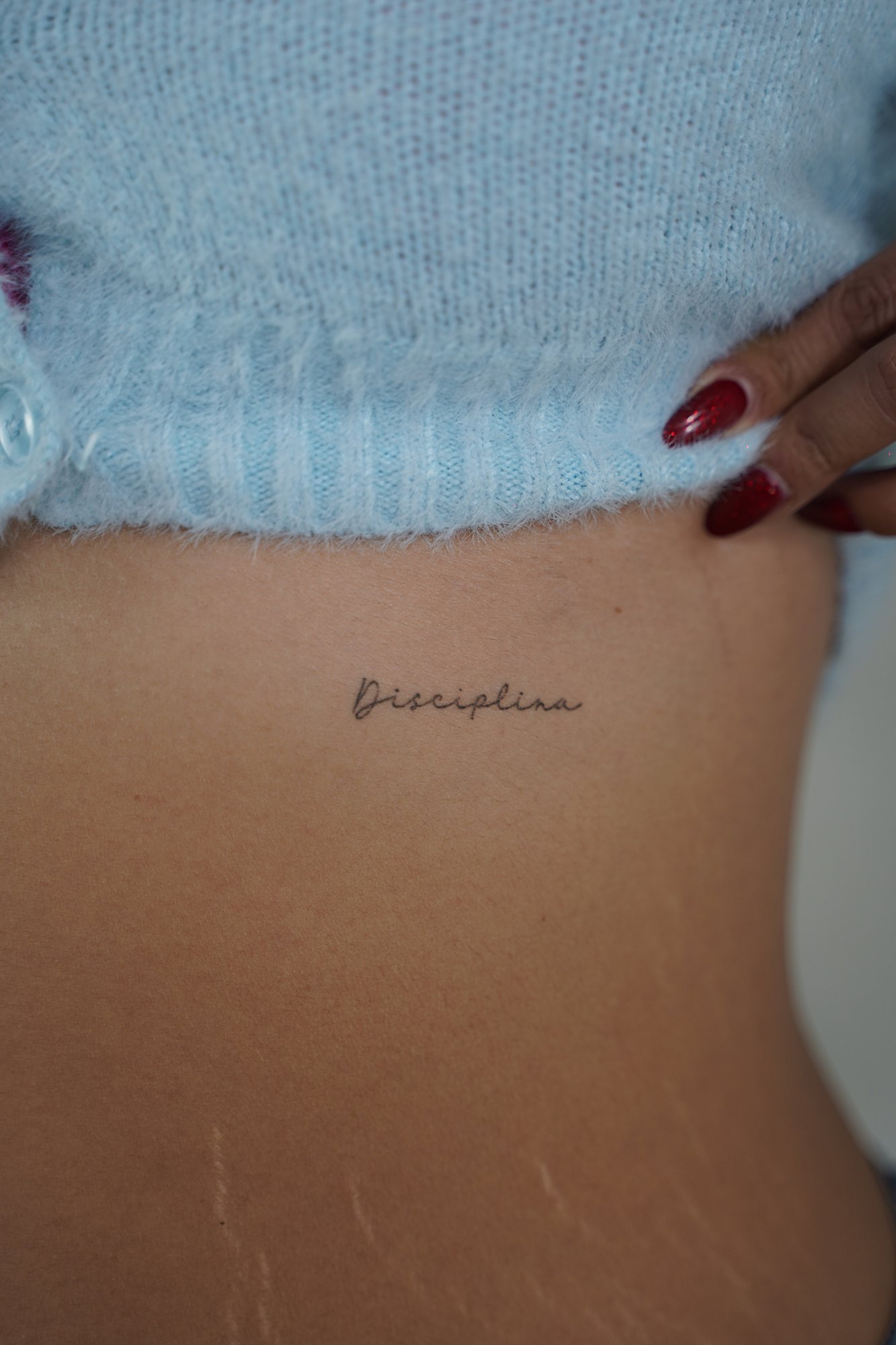 Tatuaje de frase italiana en zona desconocida, línea fina