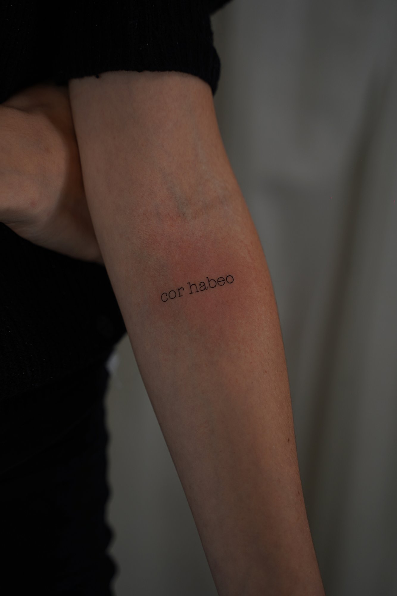 Tatuaje de frase je taime en costilla, línea fina