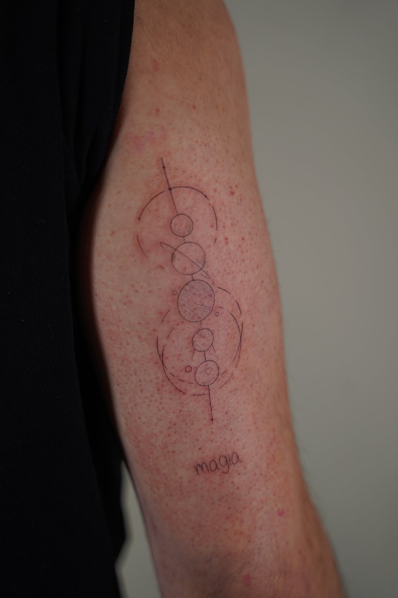Tatuaje de frase magia planetas en zona desconocida, línea fina