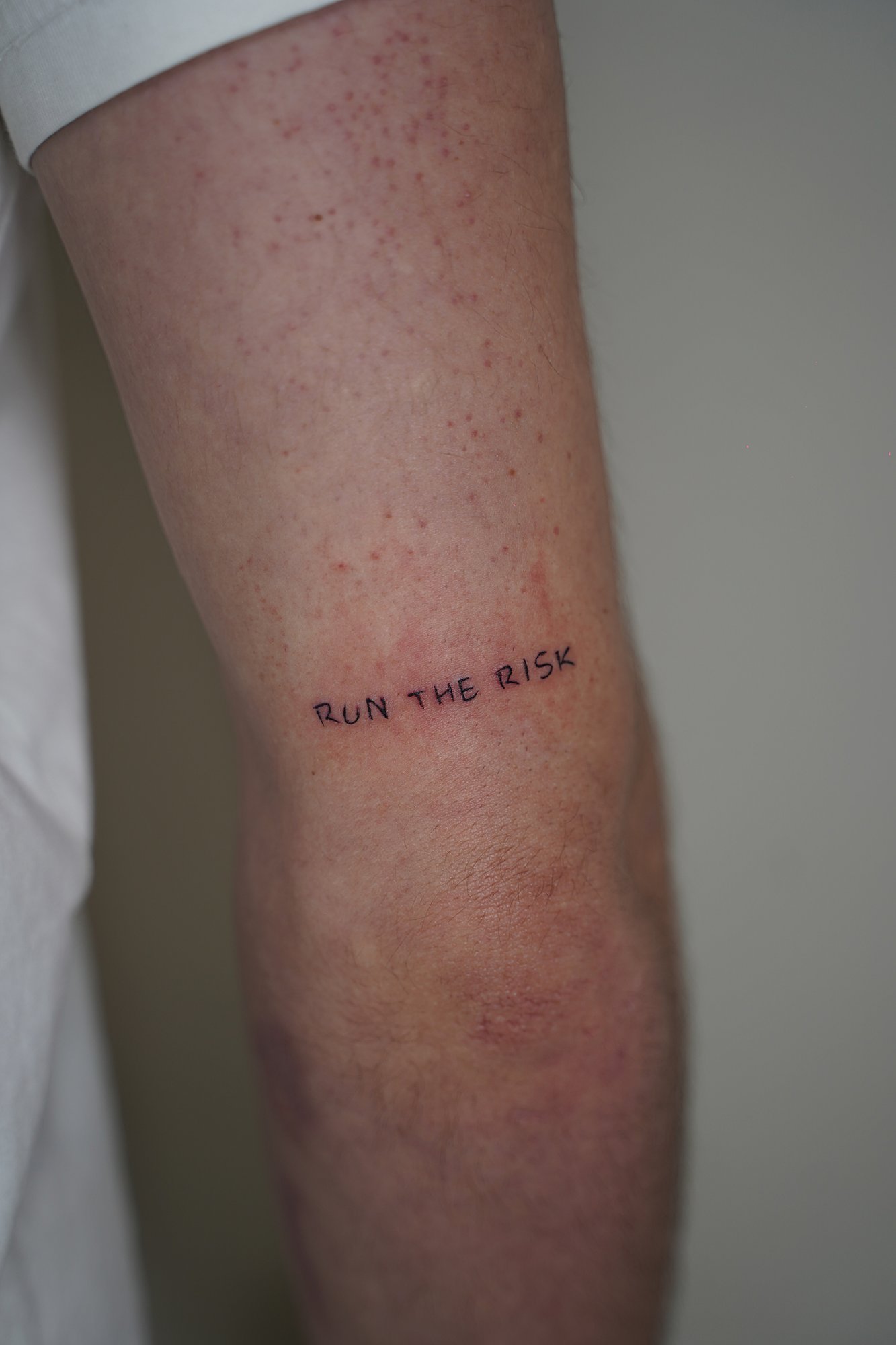 Tatuaje de frase manuscrito en zona desconocida, línea fina