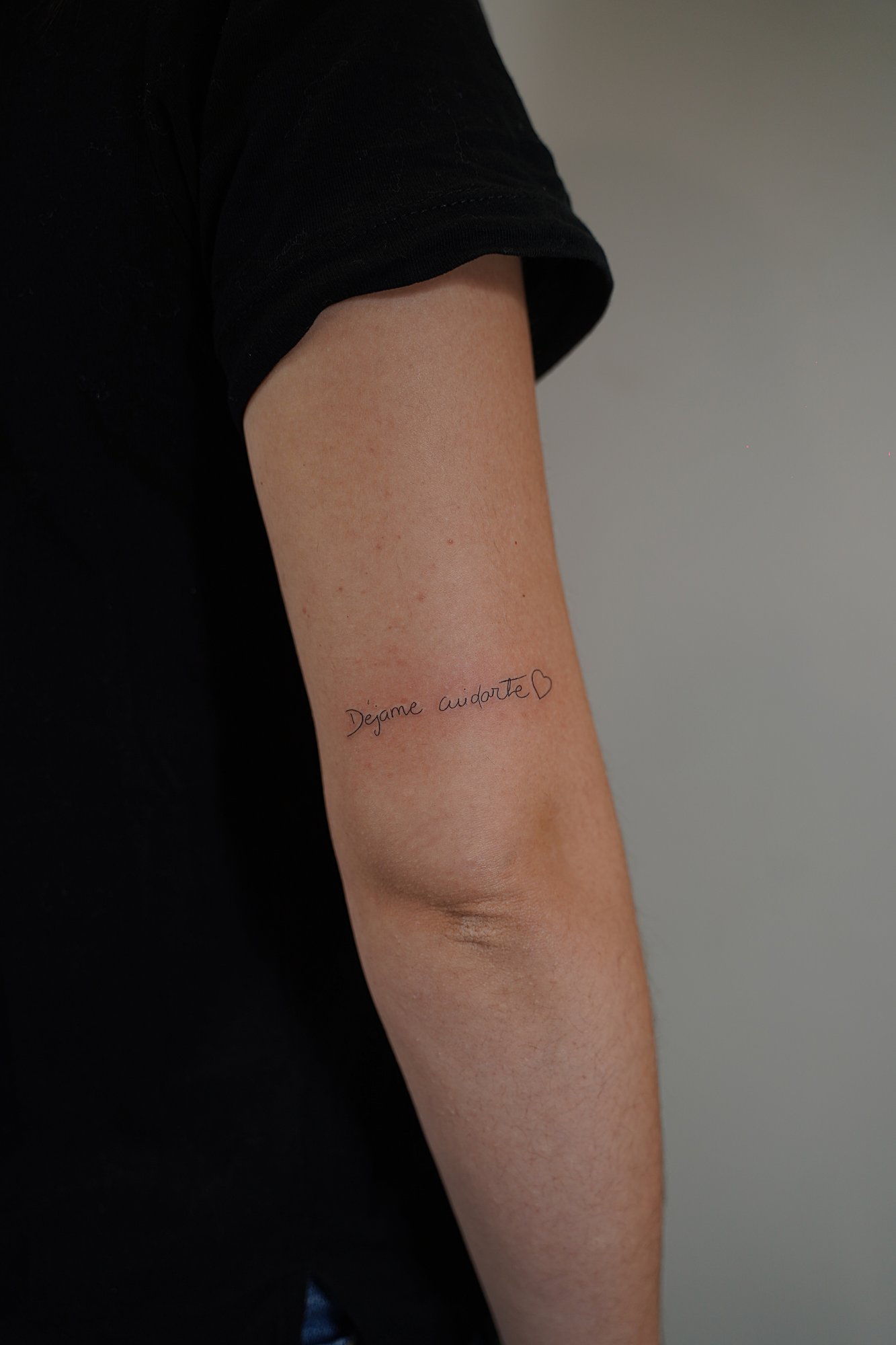 Tatuaje de frase mayuscula en zona desconocida, línea fina