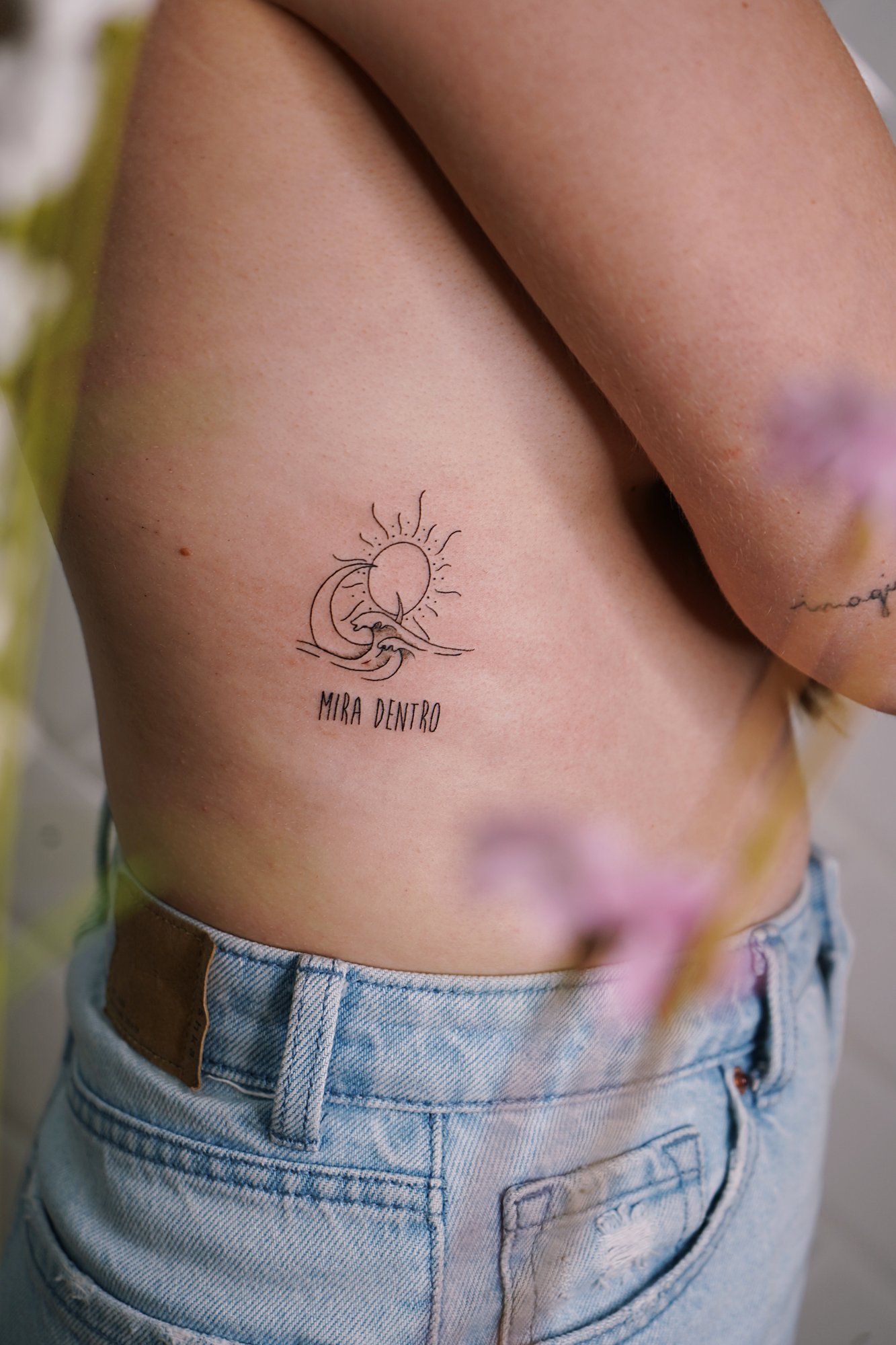 Tatuaje de frase mira dentro en costilla, línea fina