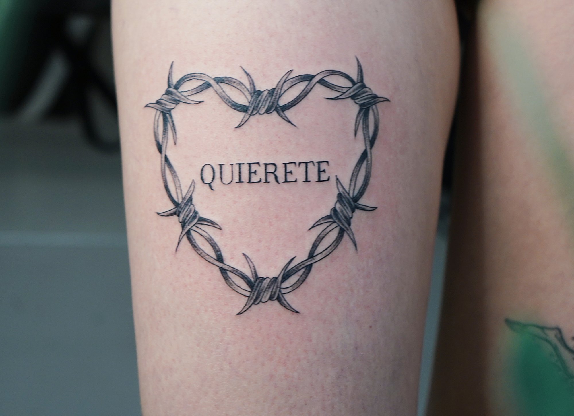Tatuaje de frase quierete en zona desconocida, línea fina