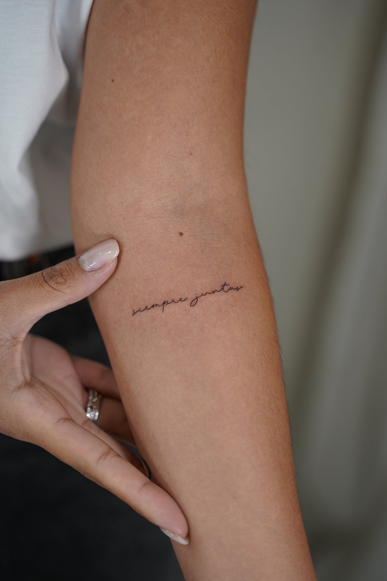 Tatuaje de frase siempre juntas en antebrazo, línea fina