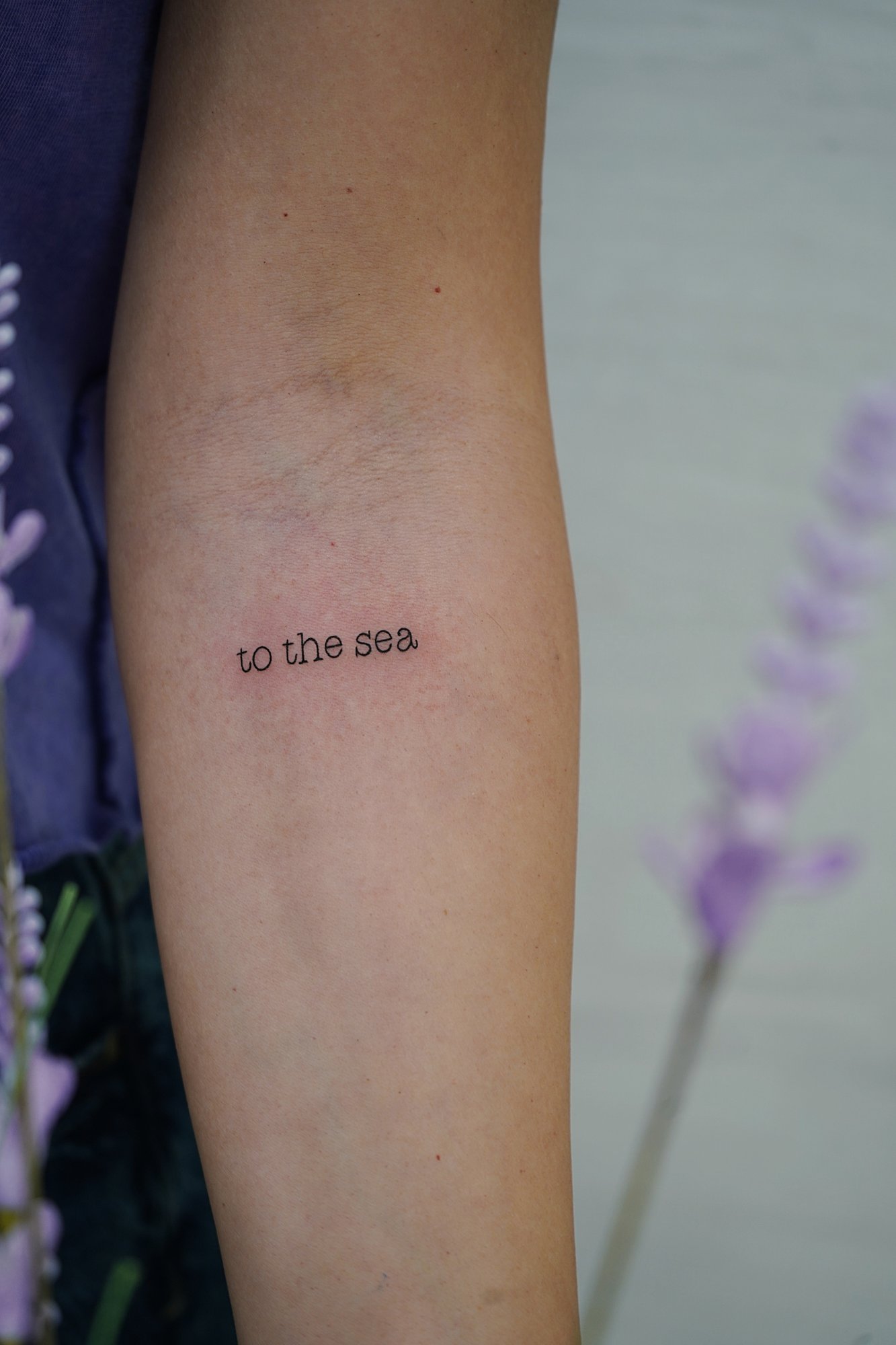 Tatuaje de frase to the sea en zona desconocida, línea fina