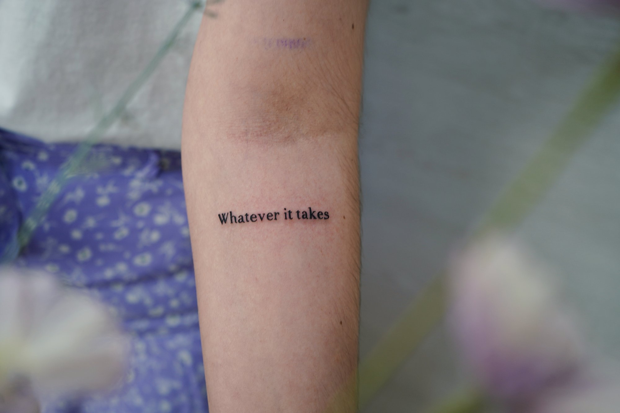 Tatuaje de frase whatever en antebrazo, línea fina