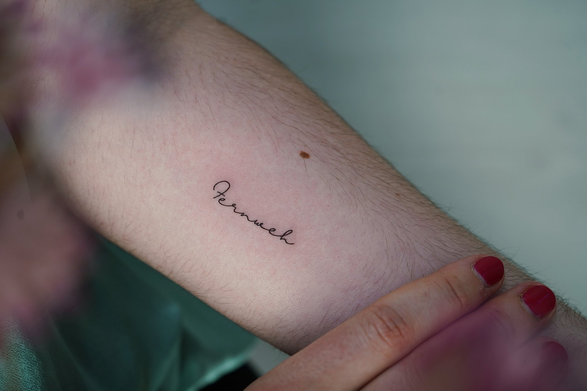 Tatuaje de frase en antebrazo, línea fina