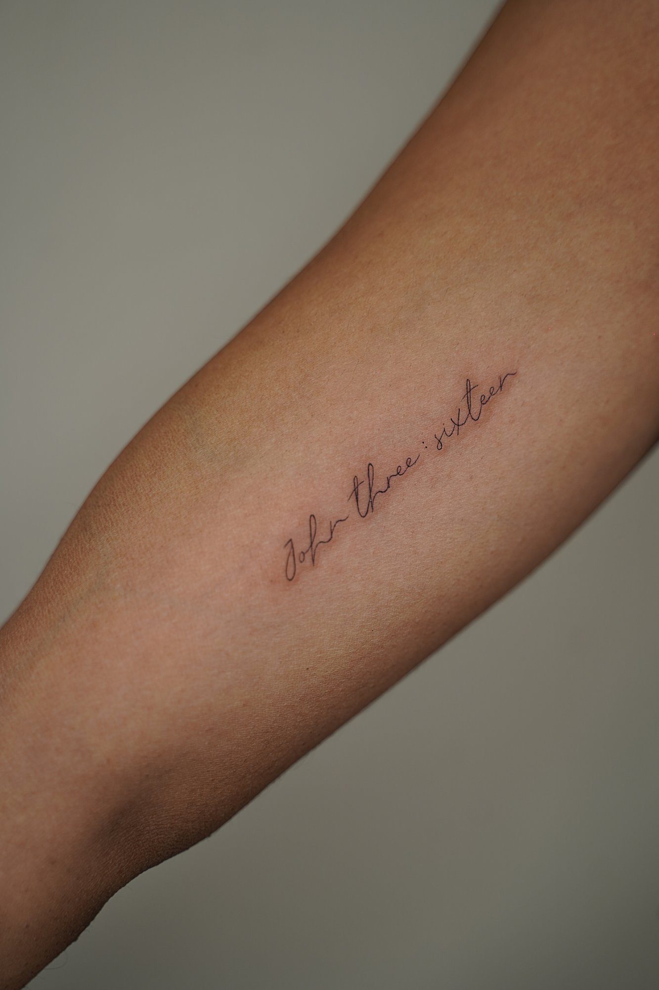 Tatuaje de frase en antebrazo, línea fina