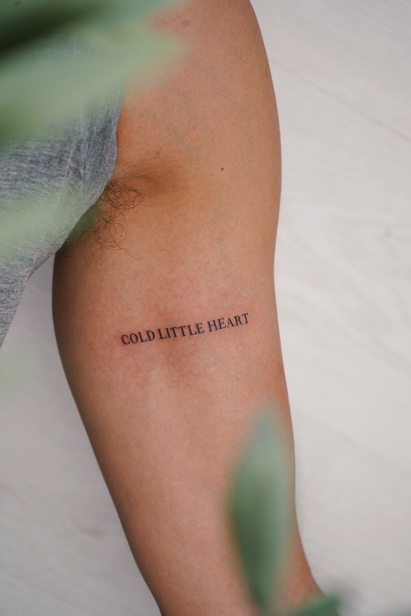 Tatuaje de frase en brazo, línea fina