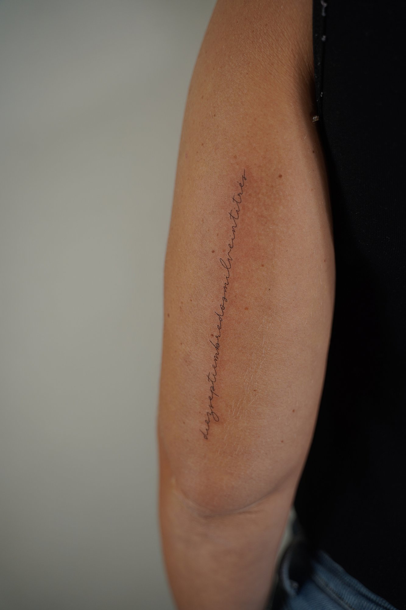 Tatuaje de frase en codo, línea fina