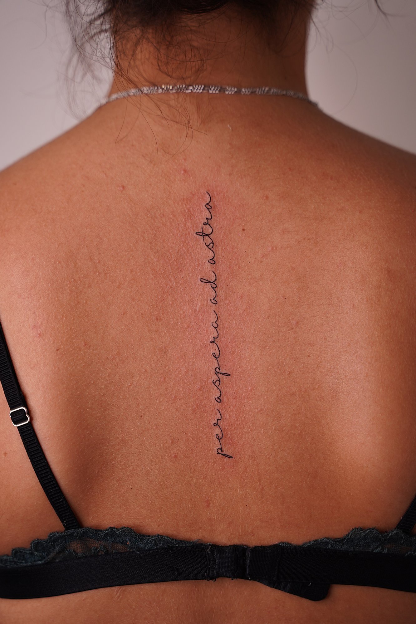 Tatuaje de frase en columna, línea fina
