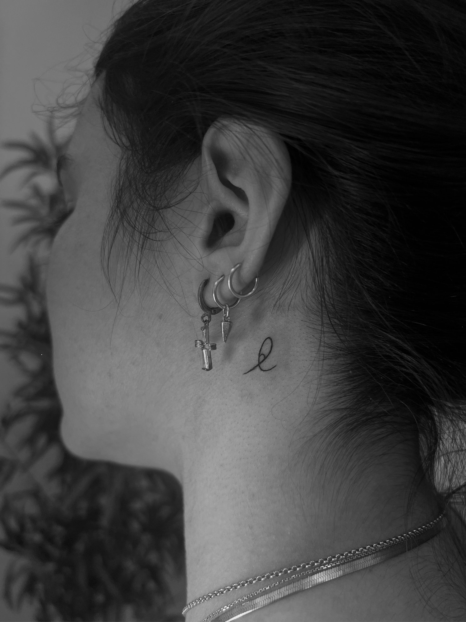 Tatuaje de letra cursiva detras oreja en detras oreja, línea fina