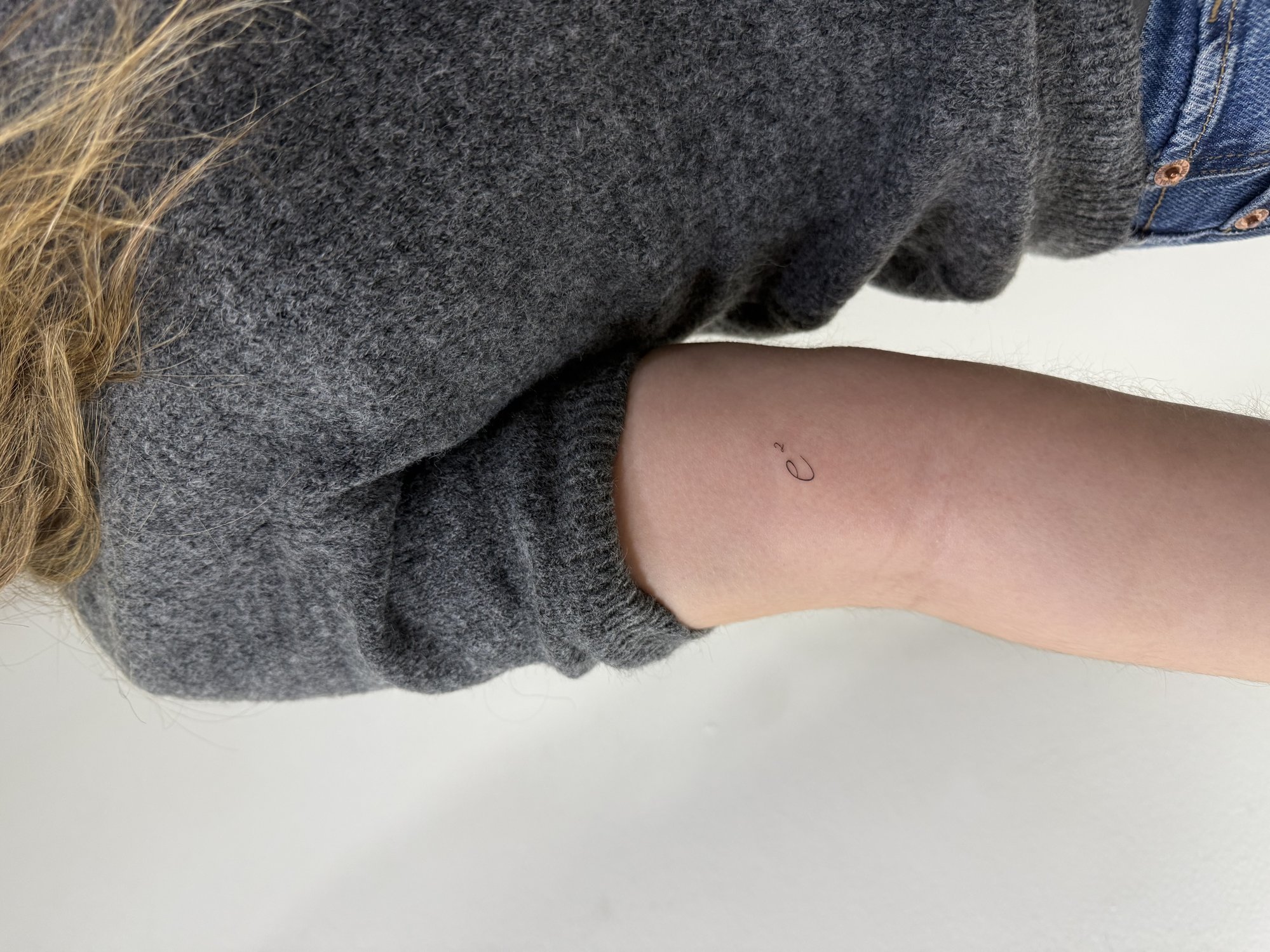 Tatuaje de letra e en zona desconocida, línea fina