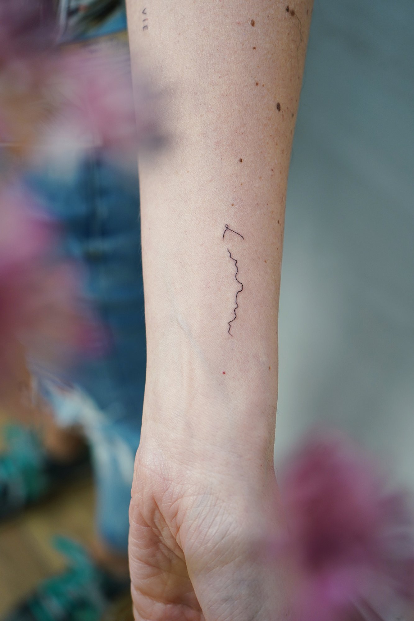 Tatuaje de letra l skyline en brazo, línea fina