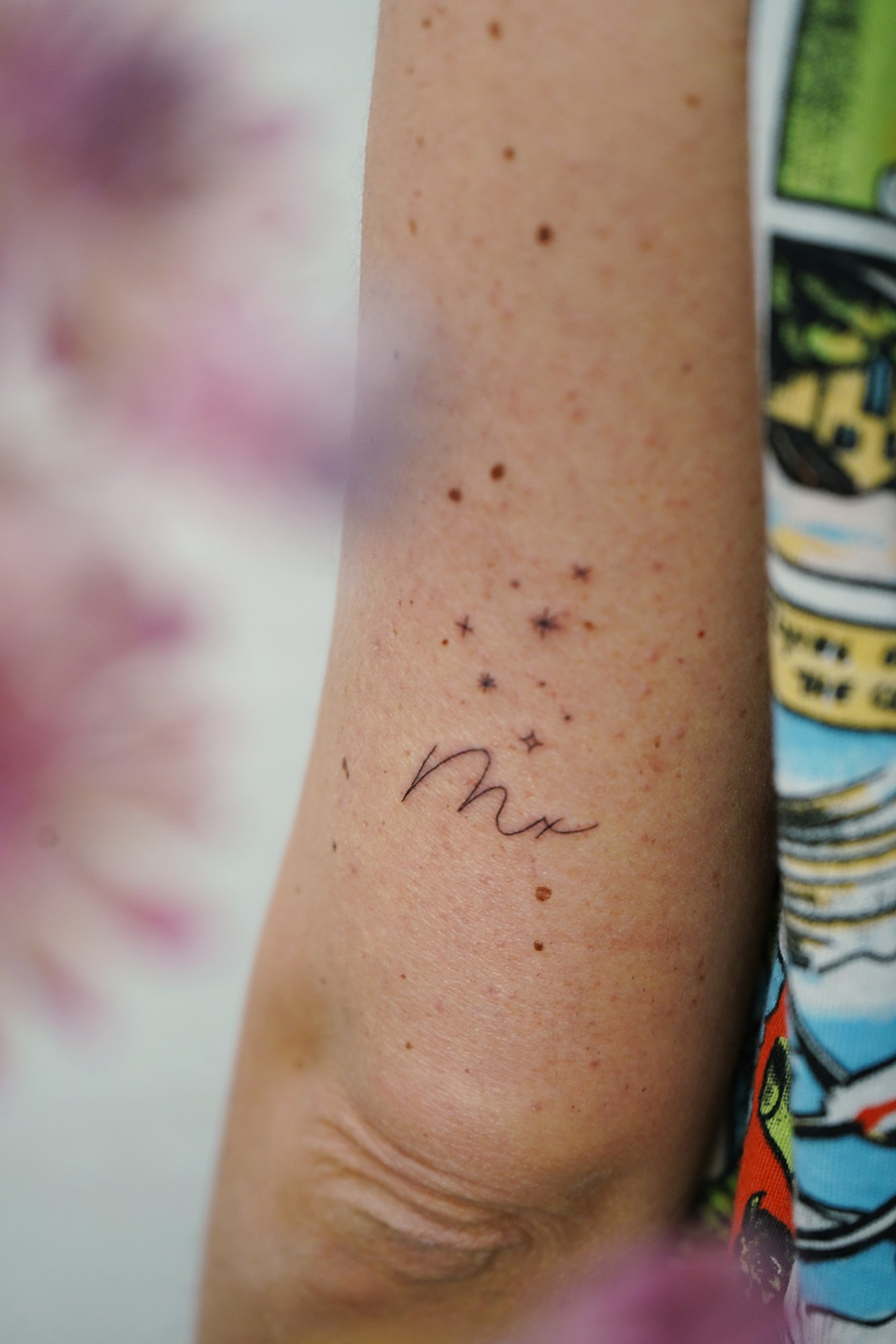 Tatuaje de letra m en codo, línea fina