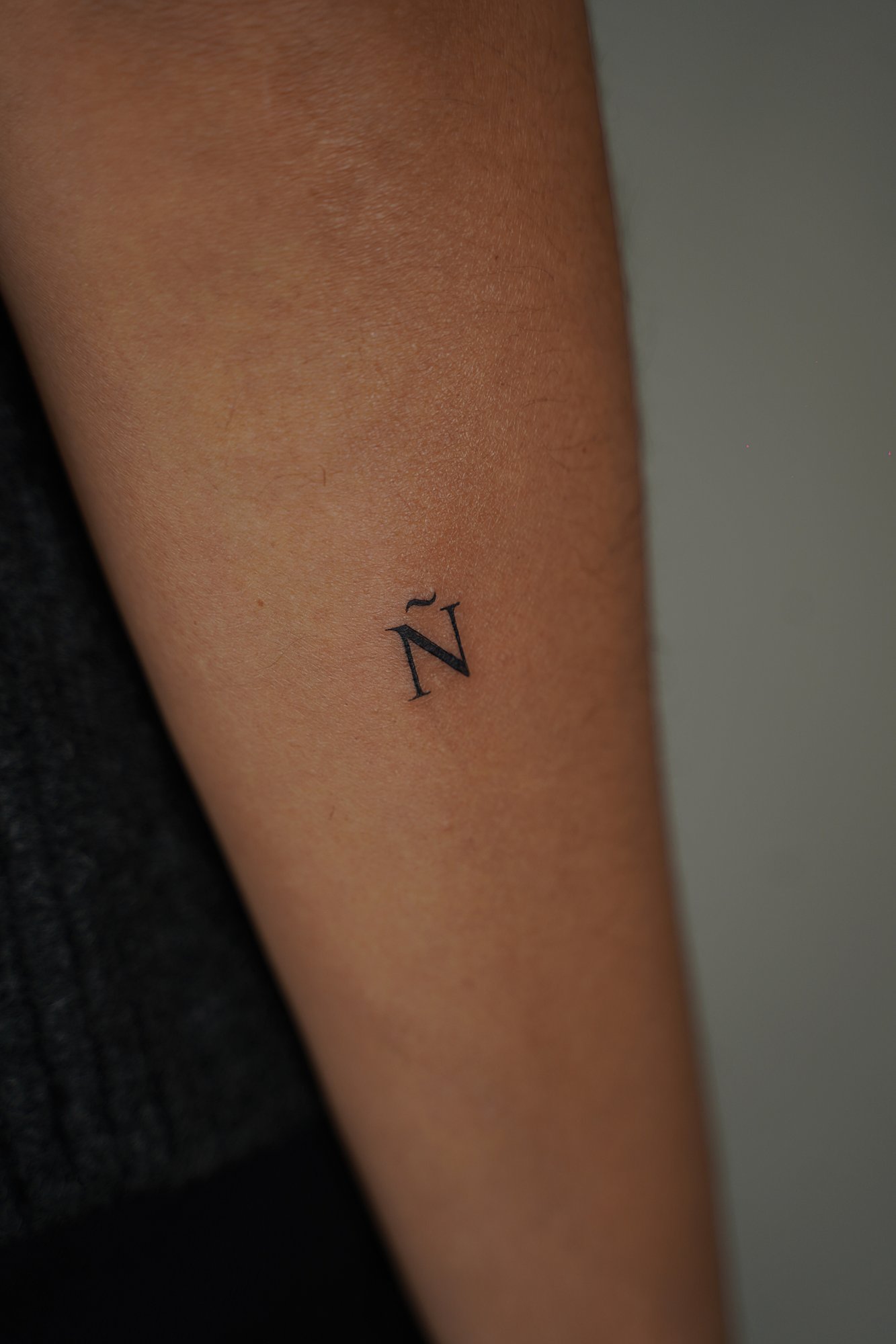 Tatuaje de letra n en zona desconocida, línea fina