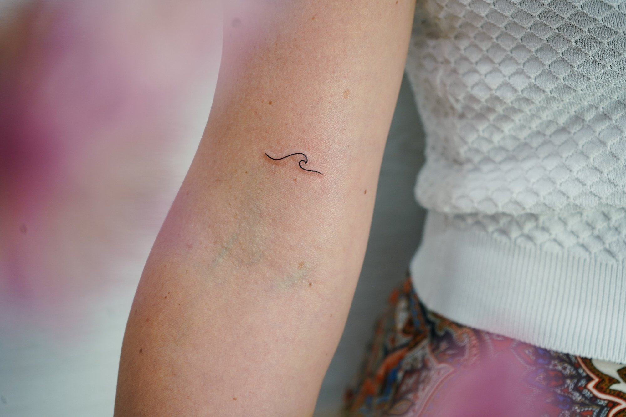 Tatuaje de letra o en brazo, línea fina