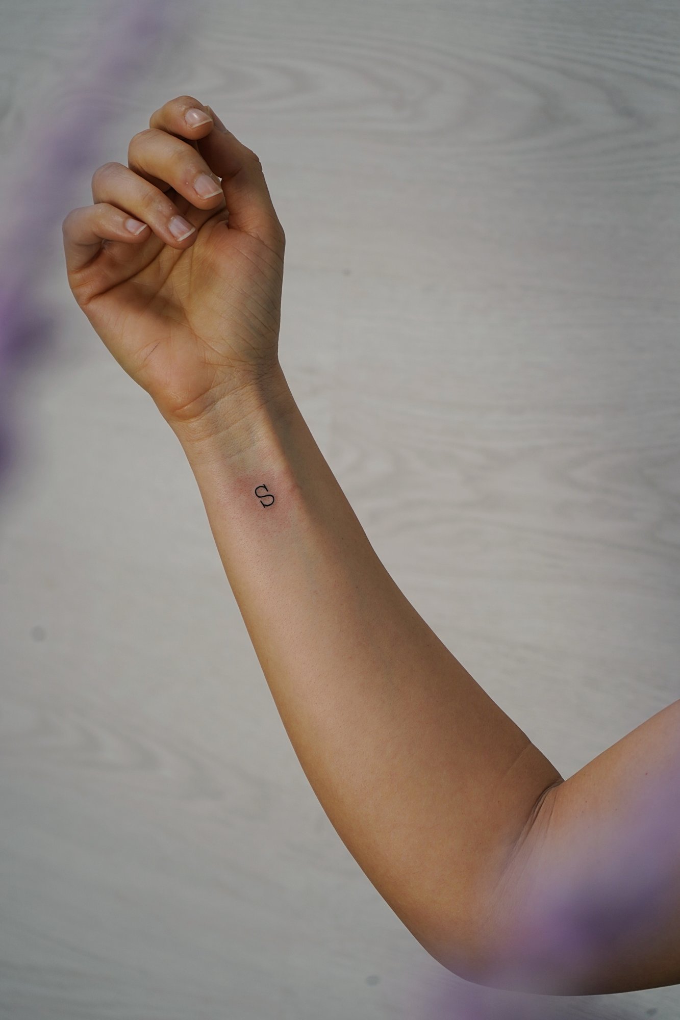Tatuaje de letra s en muneca, línea fina