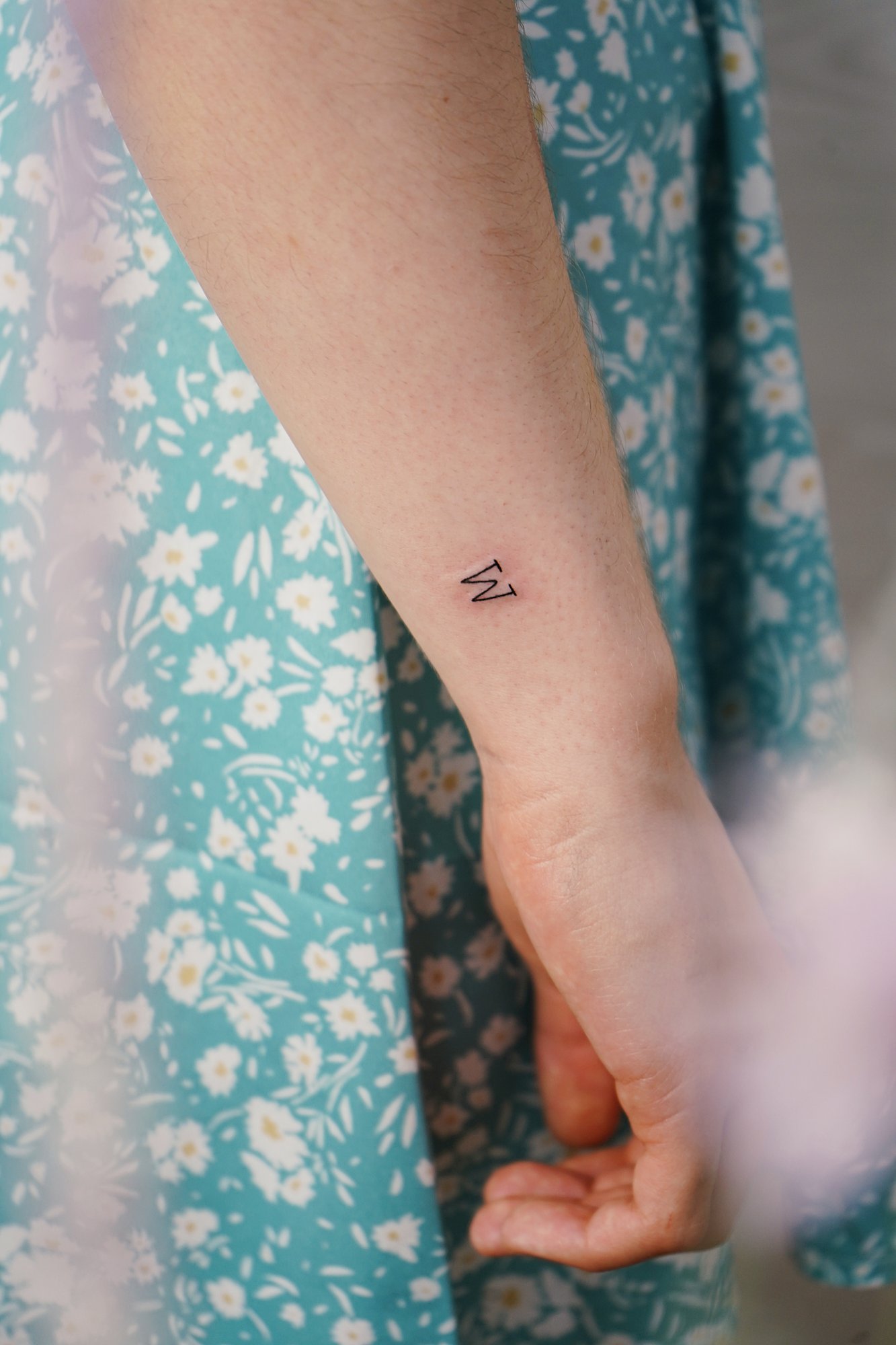 Tatuaje de letra w en muneca, línea fina
