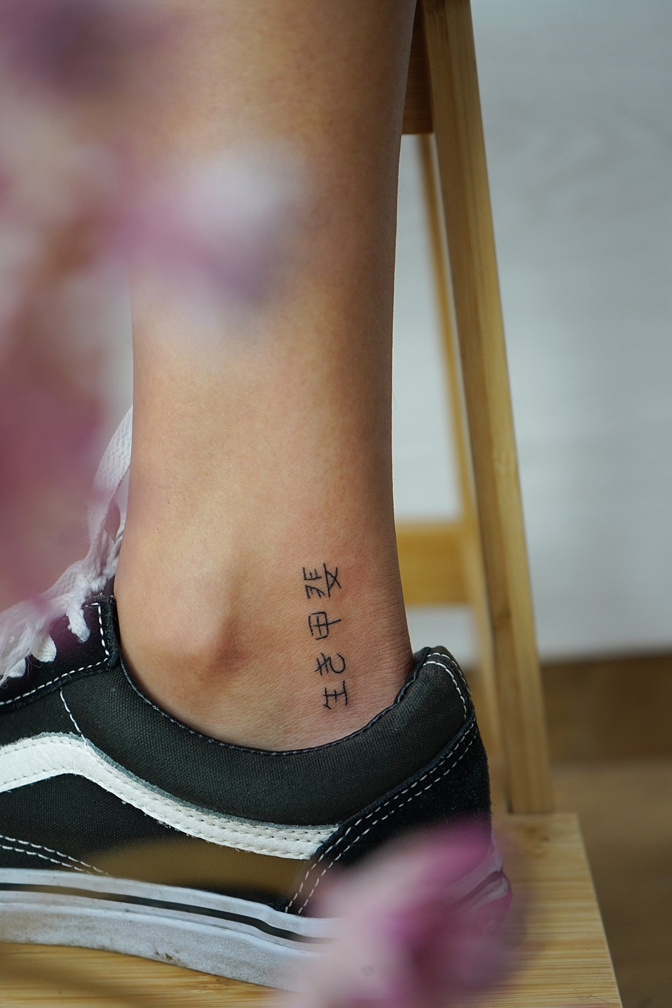 Tatuaje de letras chinas en tobillo, línea fina