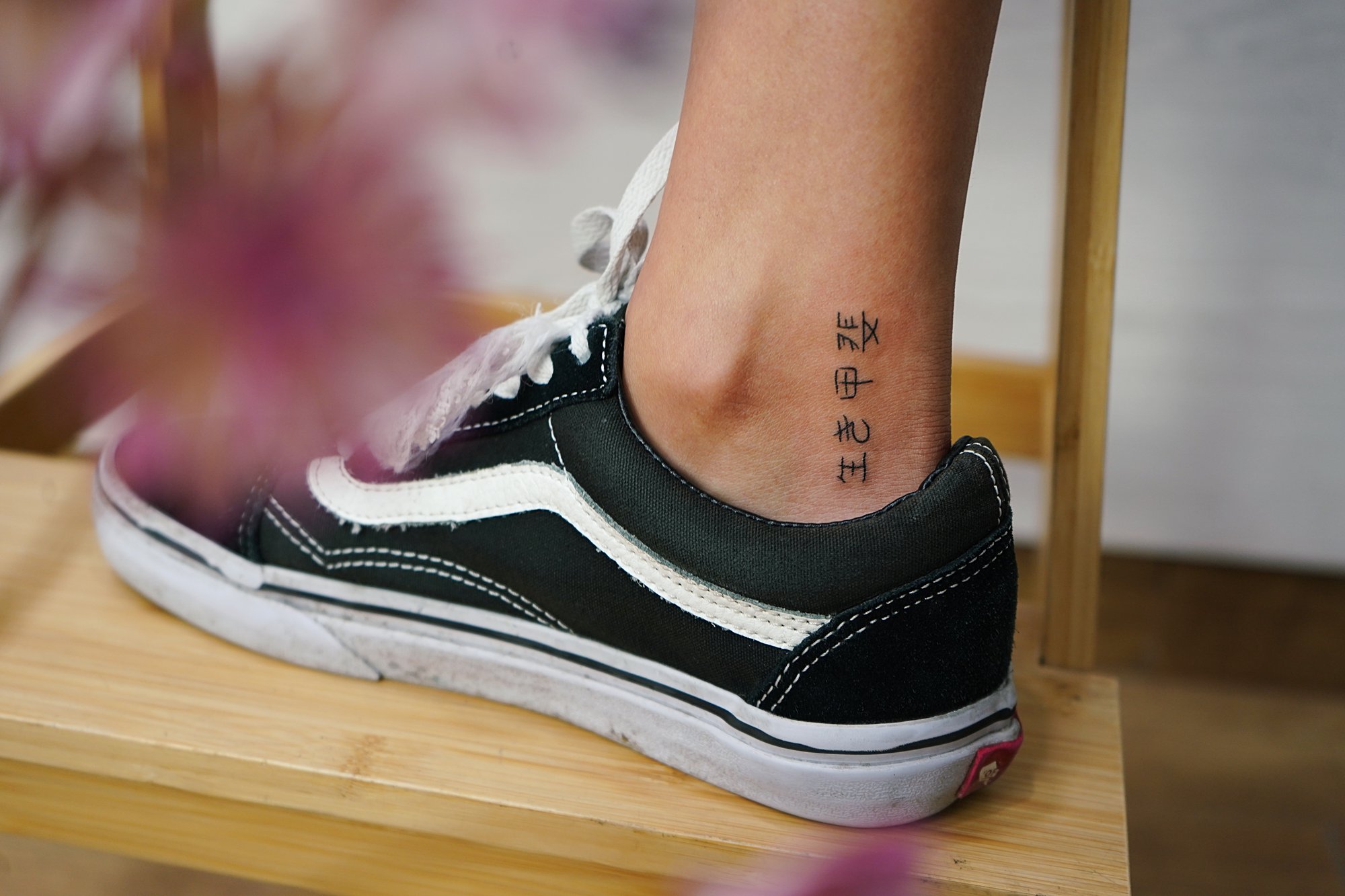 Tatuaje de letras chinas en tobillo, línea fina