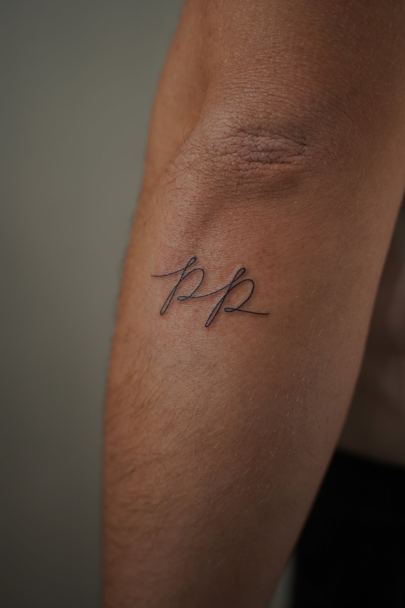 Tatuaje de letras pp en zona desconocida, línea fina