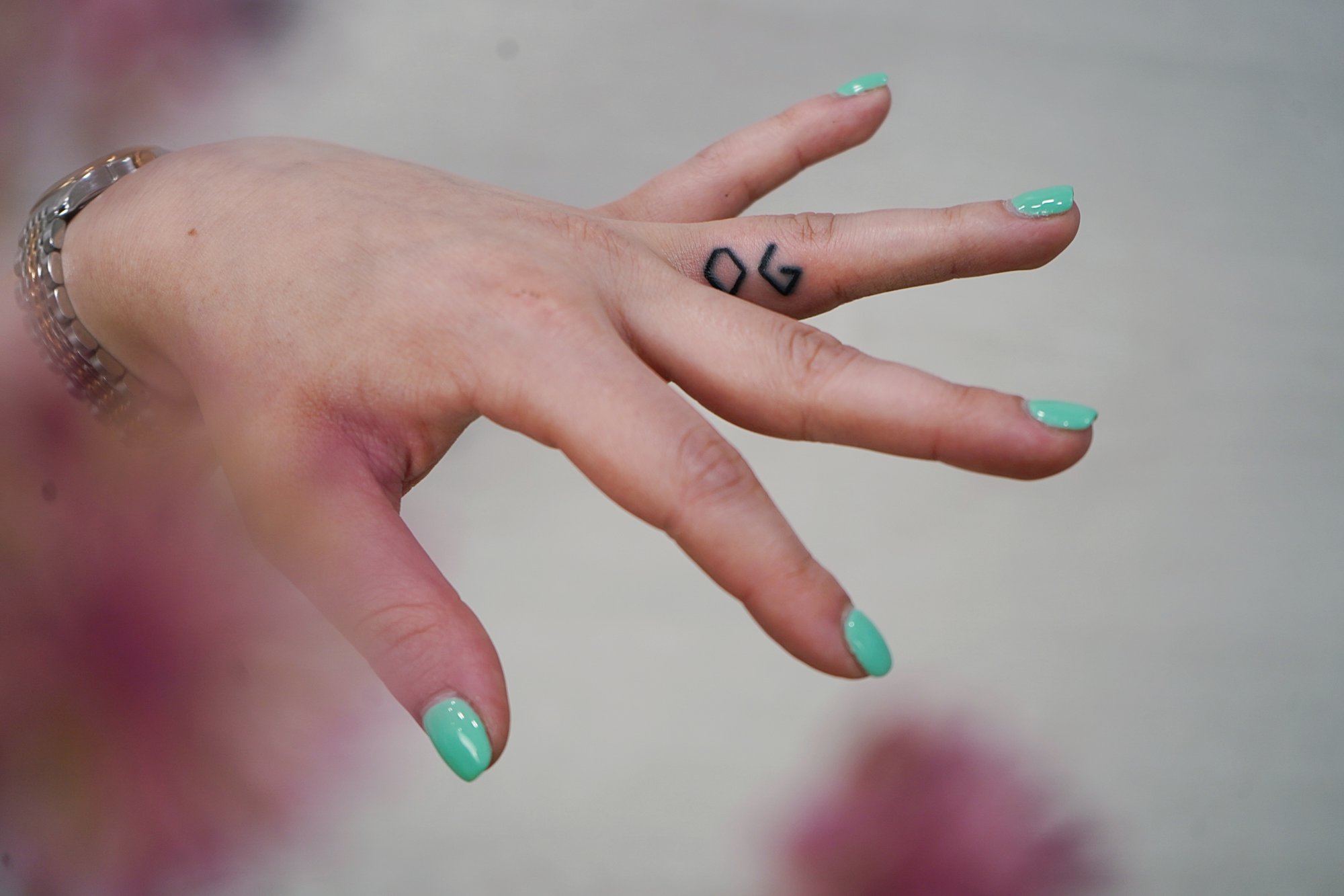 Tatuaje de letras en dedo, línea fina